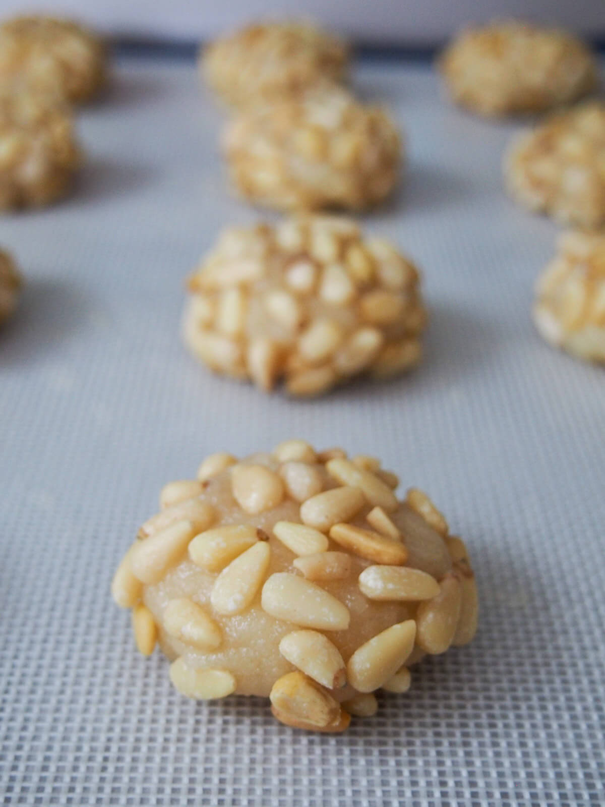 cookies covered in pine nuts before baking
