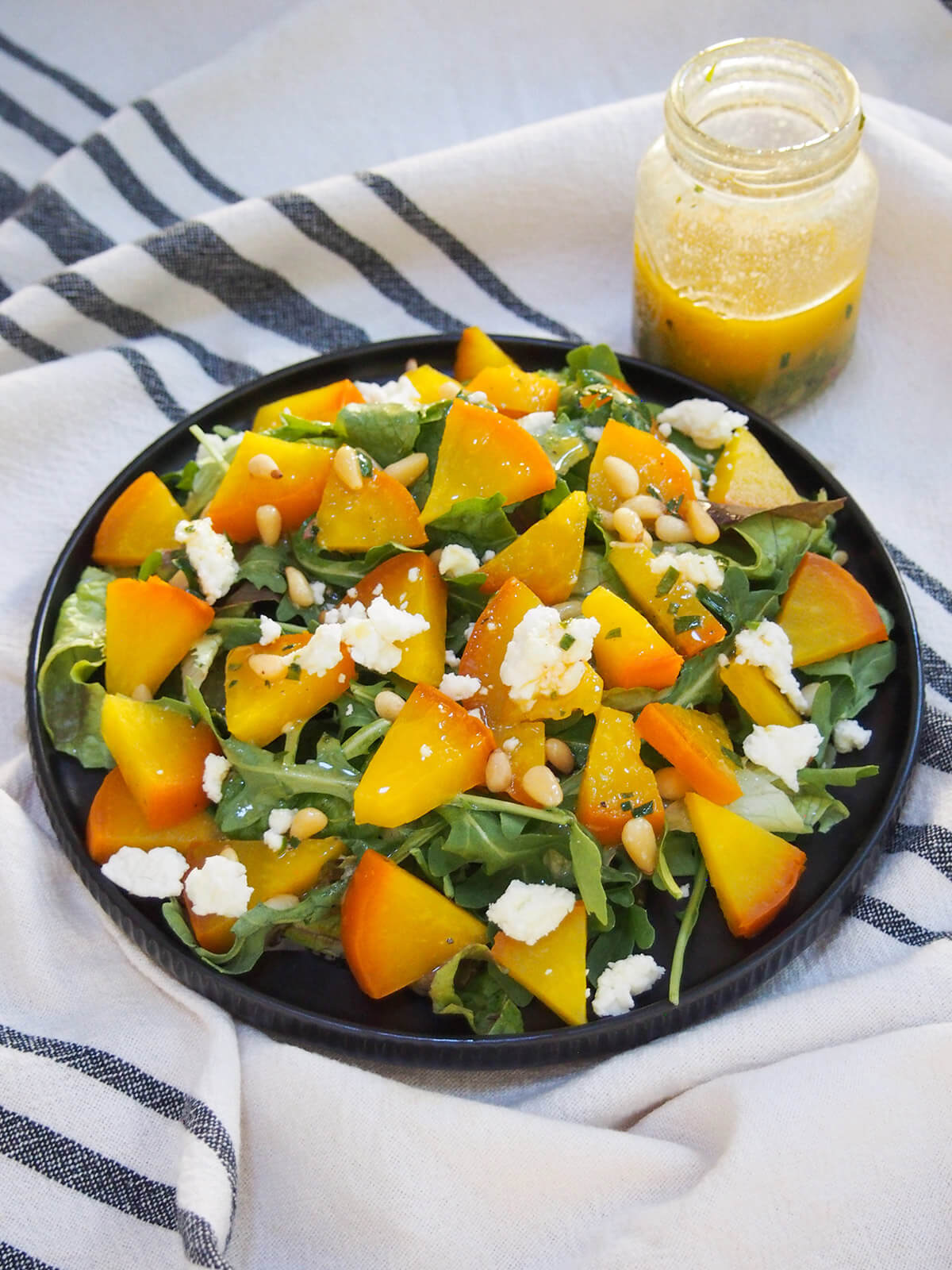 plate of roasted golden beet salad with jar of dressing behind