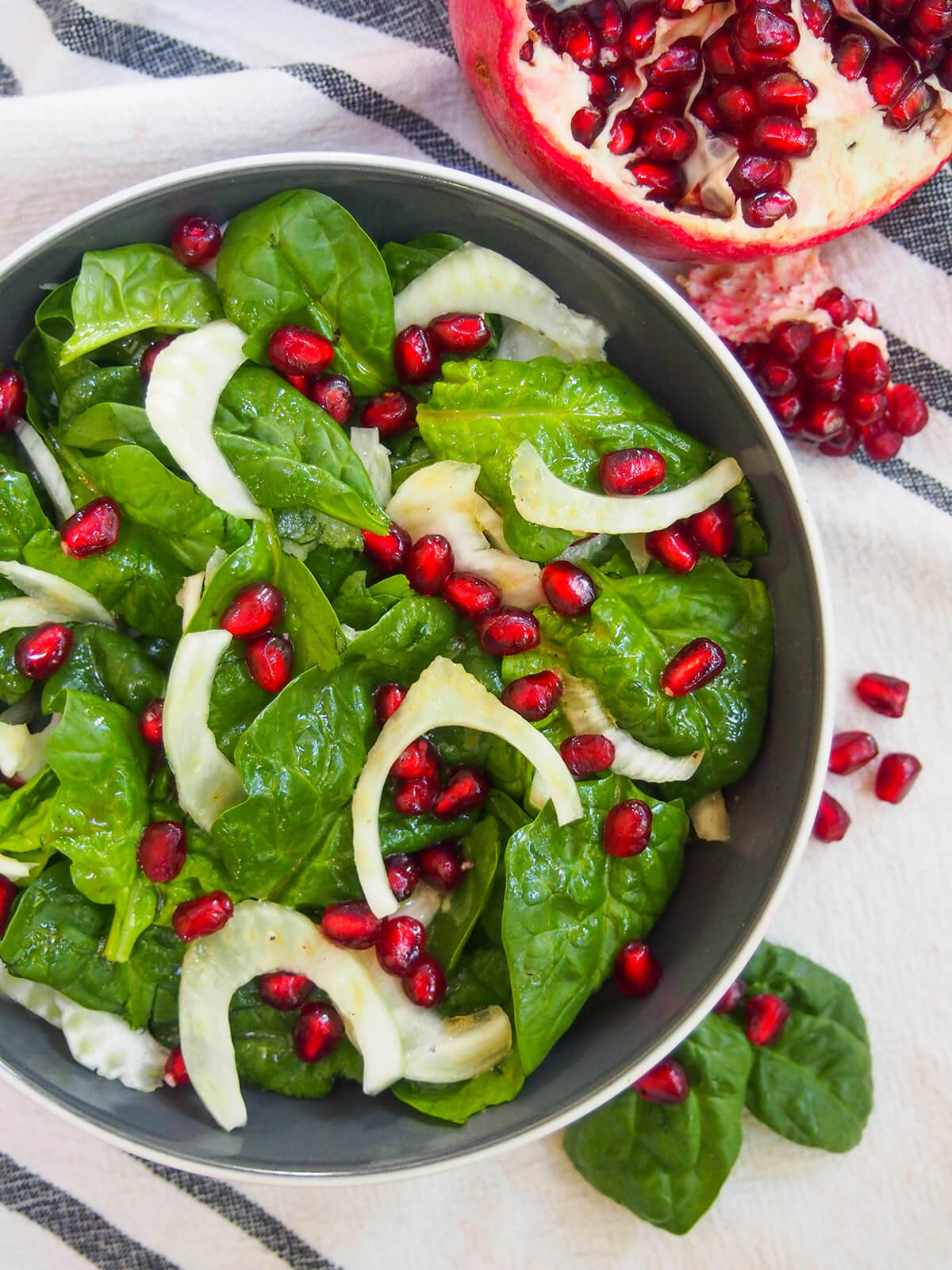 view of most of bowl of spinach pomegranate salad from overhead