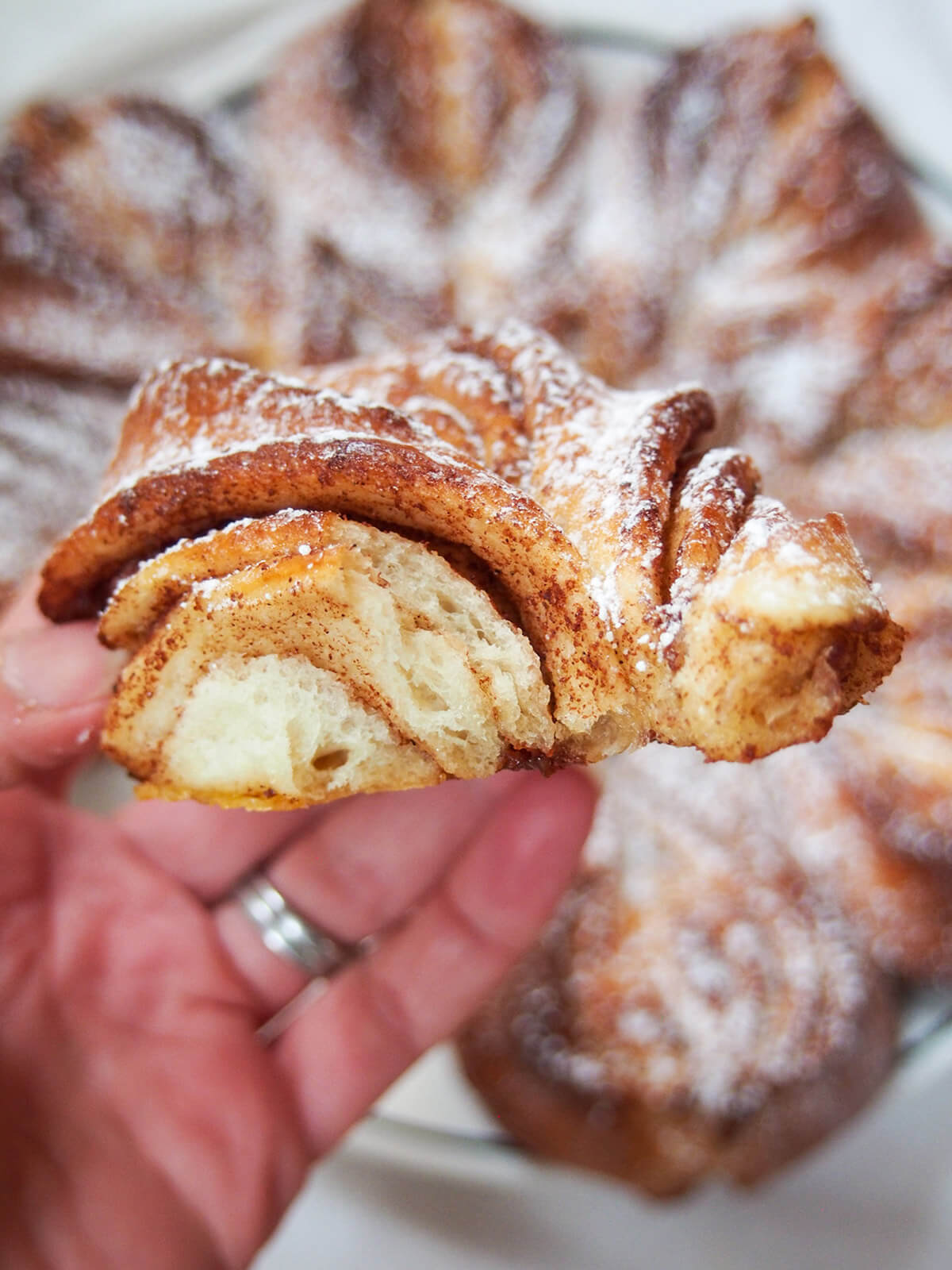 section of cinnamon star bread held in hand