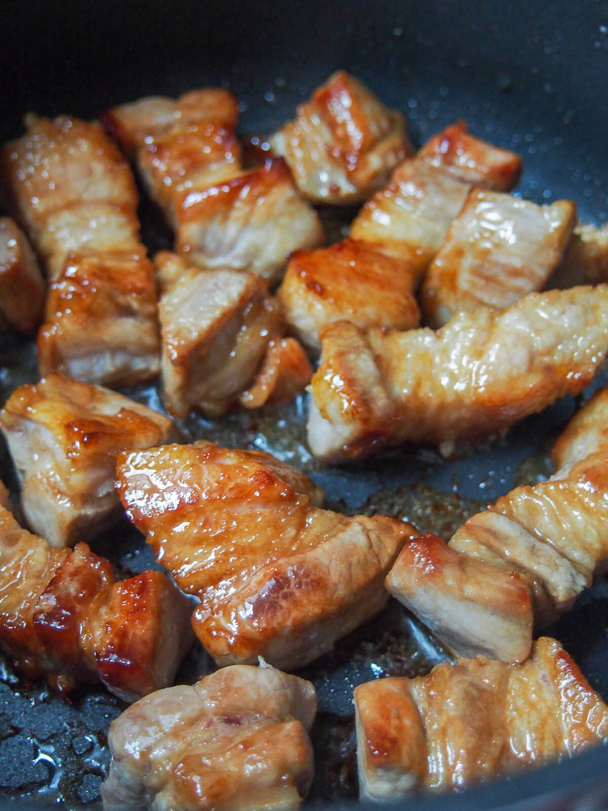 caramelizing pieces of pork belly