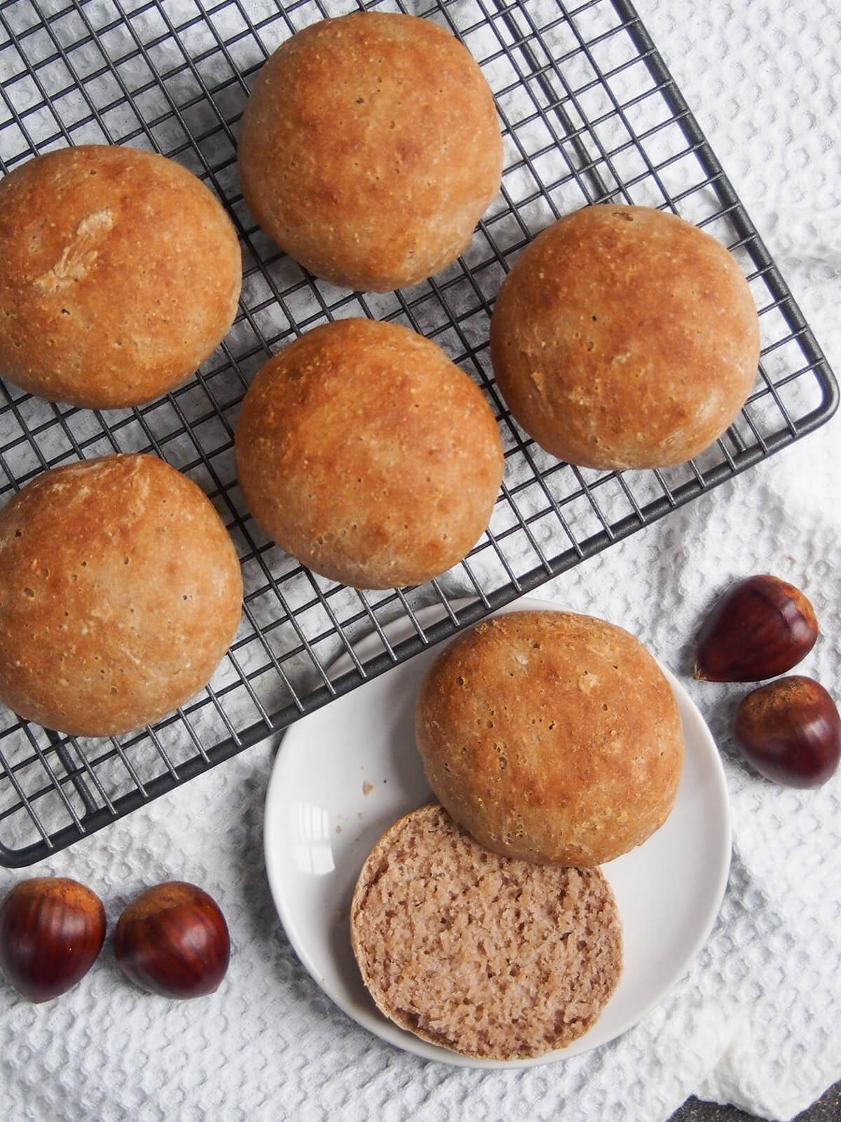 chestnut bread rolls from overhead with one on plate