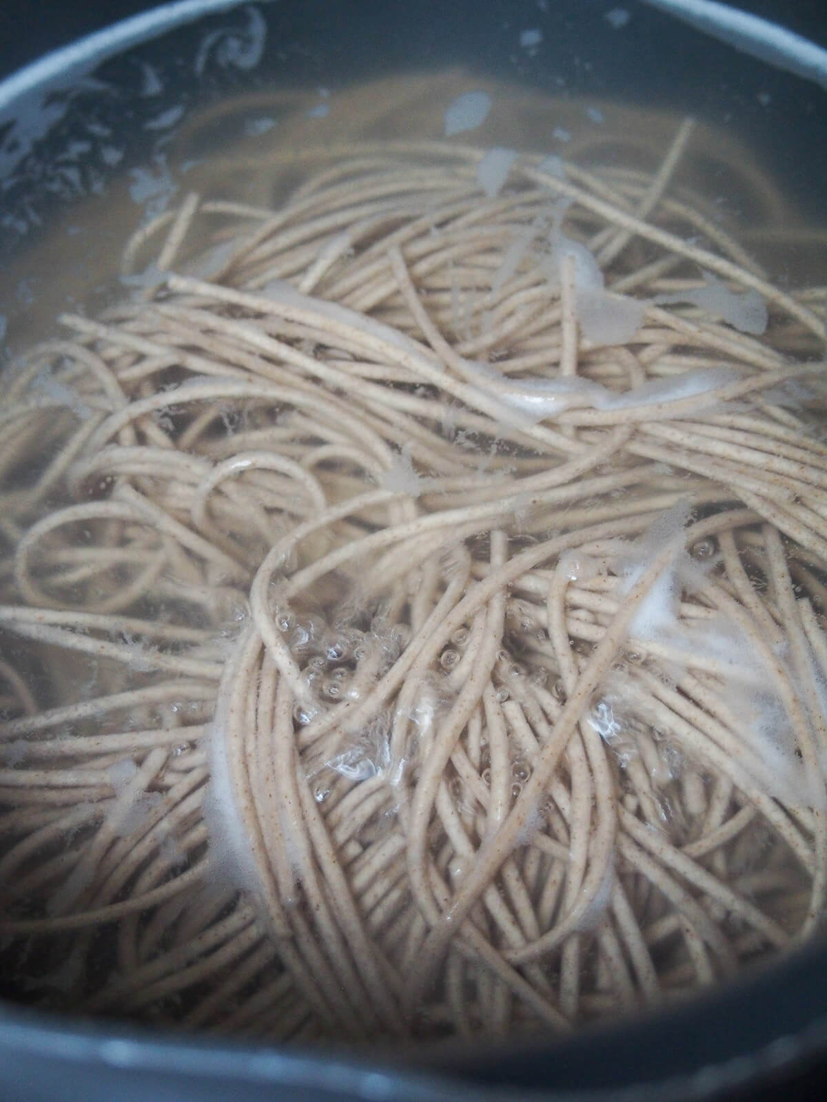 cooking soba noodles in pot of boiling water
