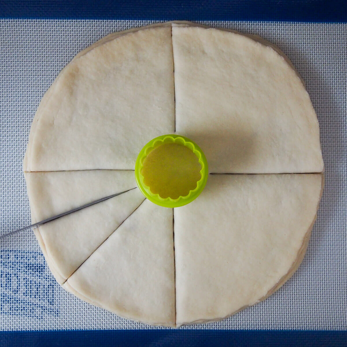 making cuts in layers of bread with cutter marking middle