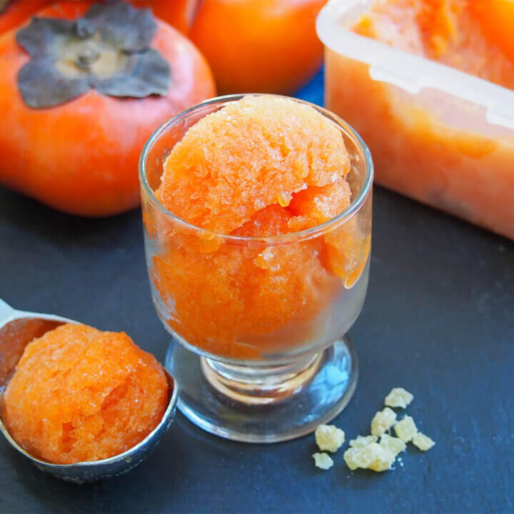 glass of persimmon ginger sorbet with scoop to side