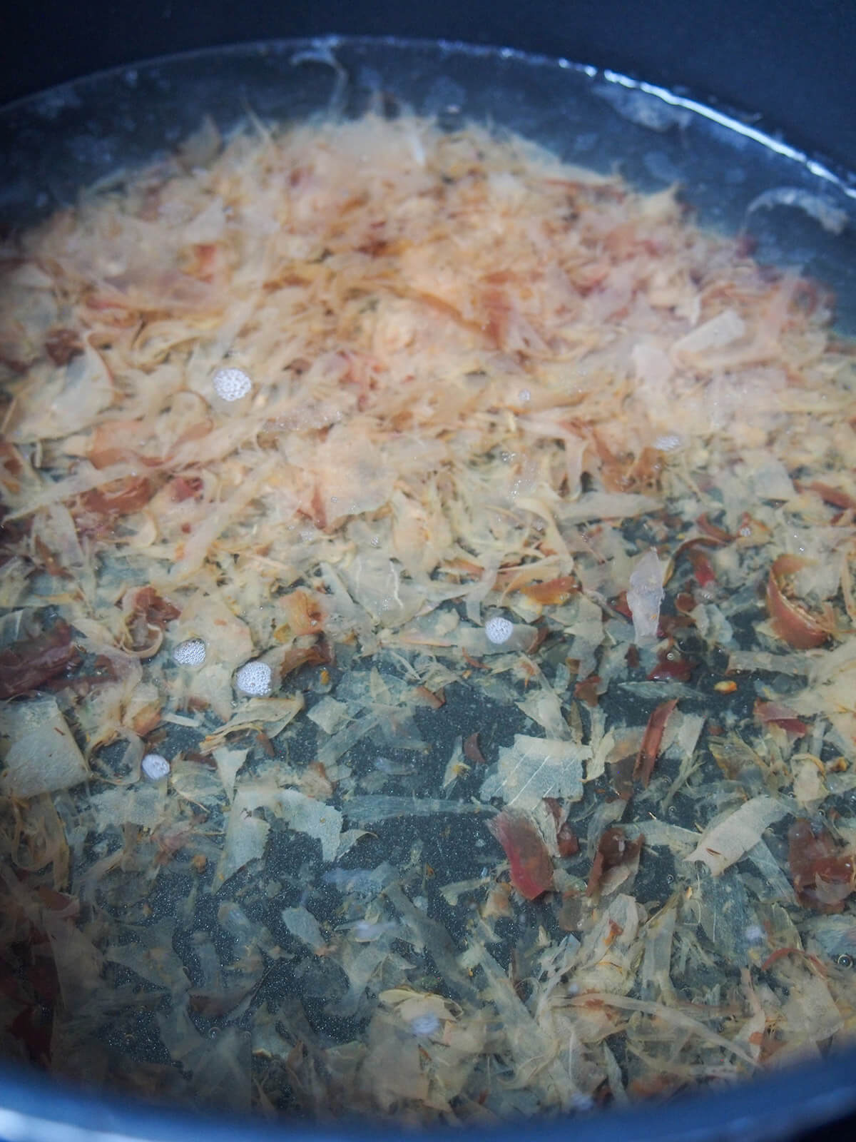 making dashi stock with bonito flakes sunk to bottom of liquid