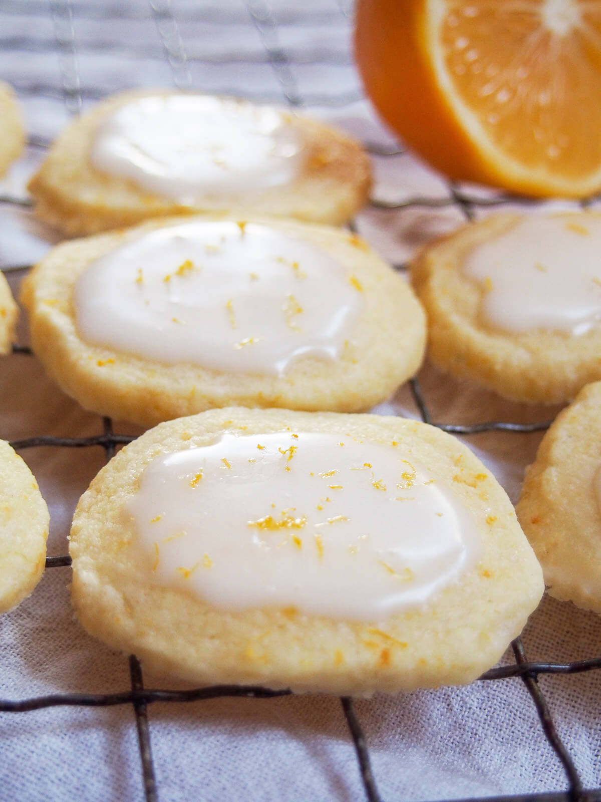close up of Meyer lemon cookies on cooling rack with Meyer lemon behind