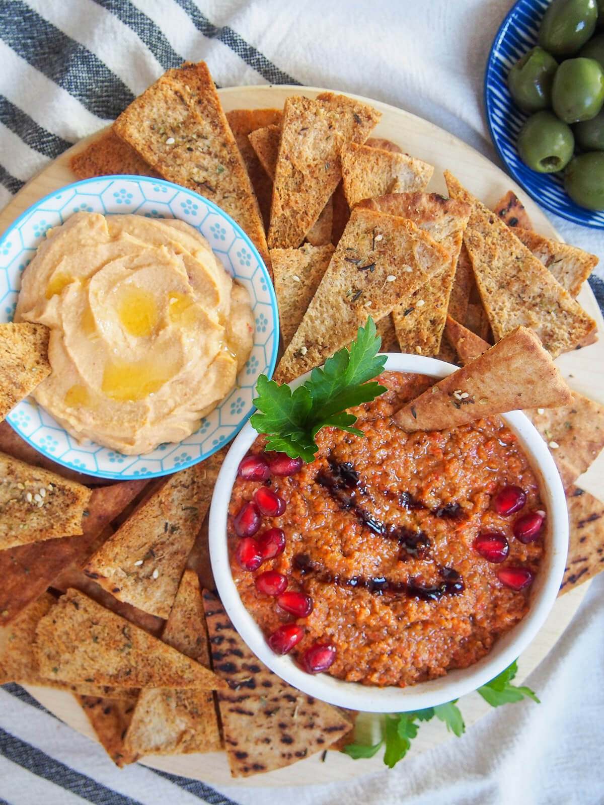 dips with baked pita chips all around the bowls