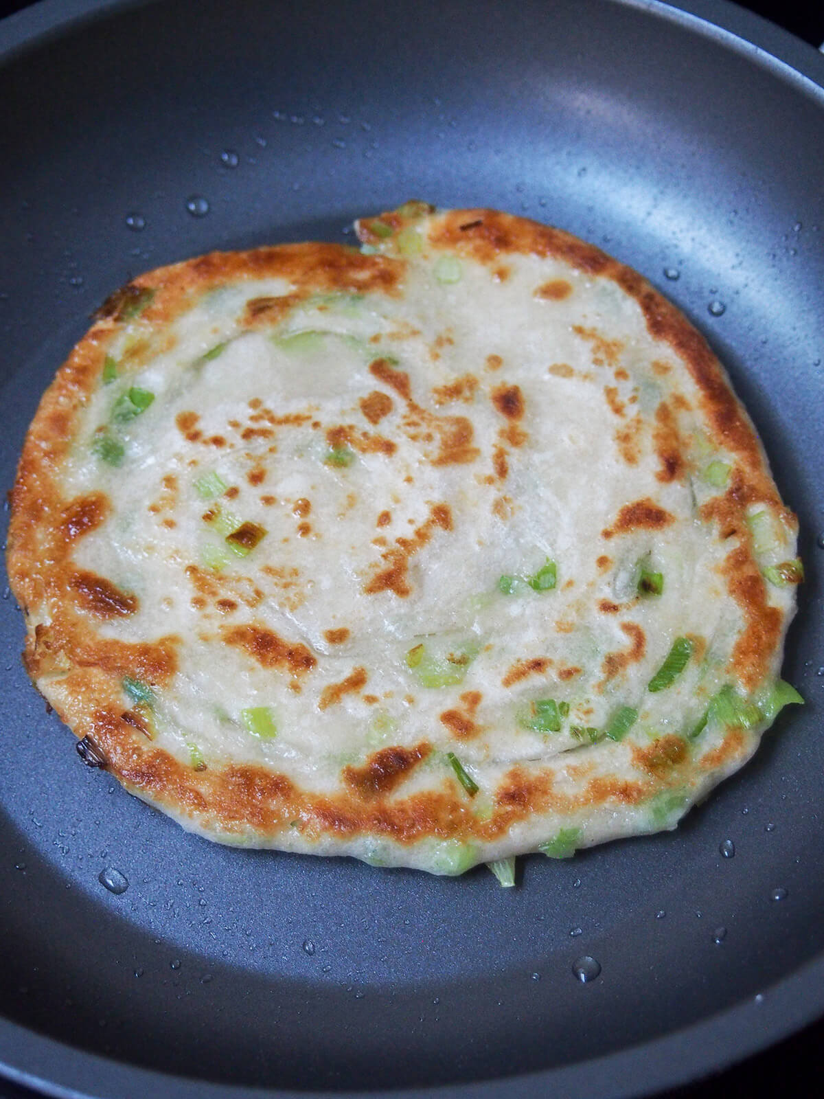 cooking scallion pancake cooking scallion pancake in skillet