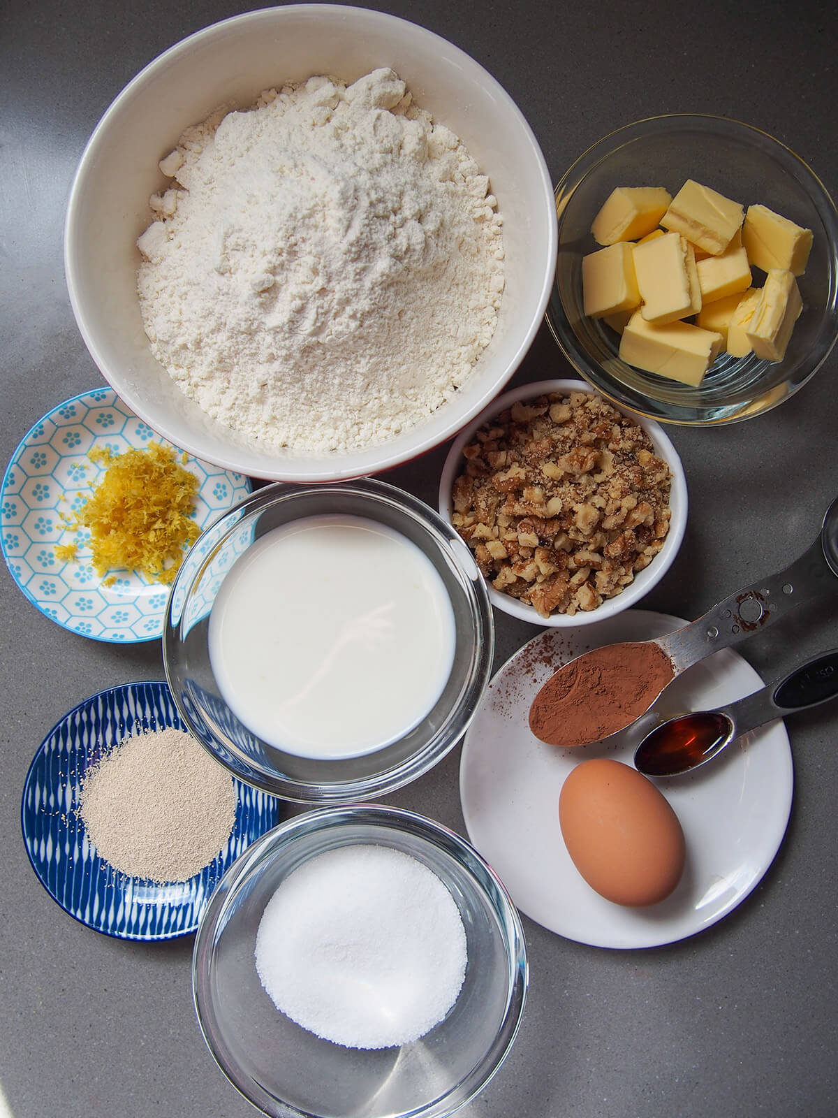 bowls with flour, butter, milk, sugar, walnuts, lemon zest and yeast