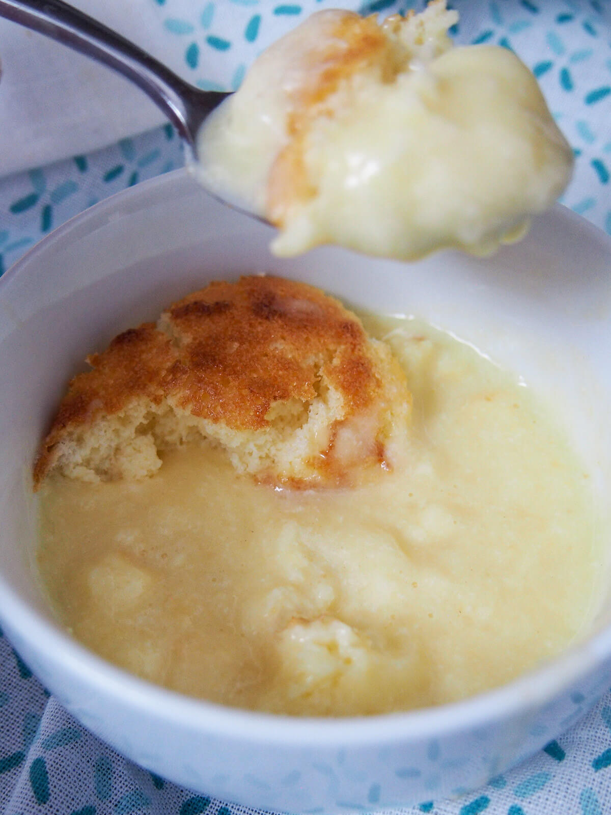 taking spoonful from bowl of lemon pudding cake