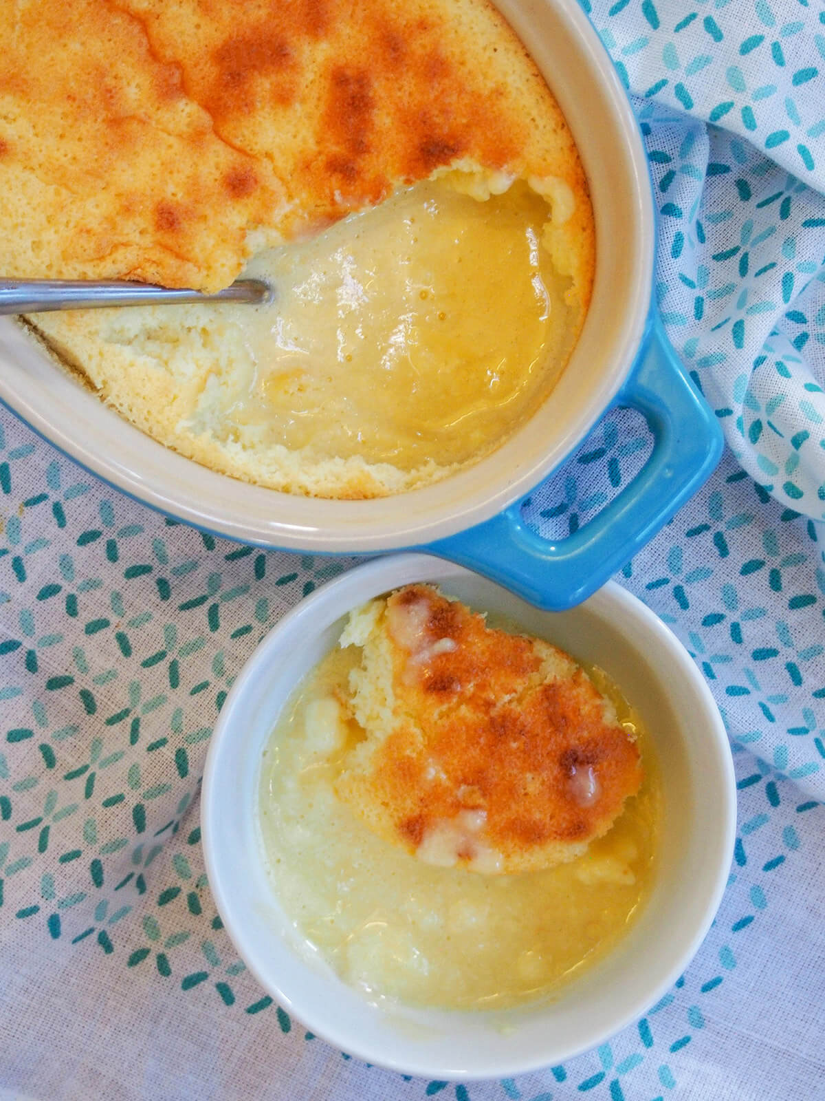 part view of lemon pudding cake in dish with bowl below