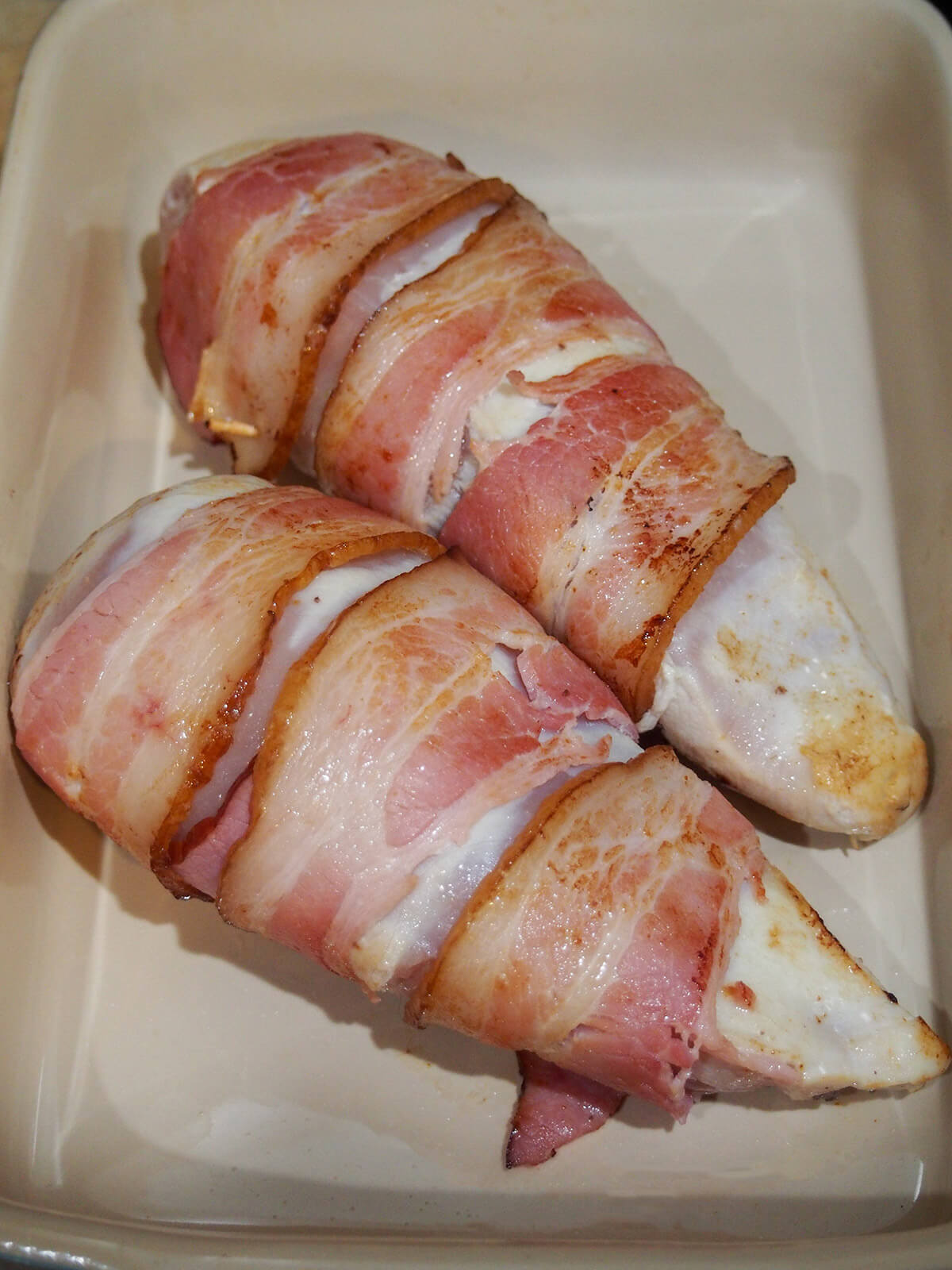 seared bacon wrapped stuffed chicken breasts in dish