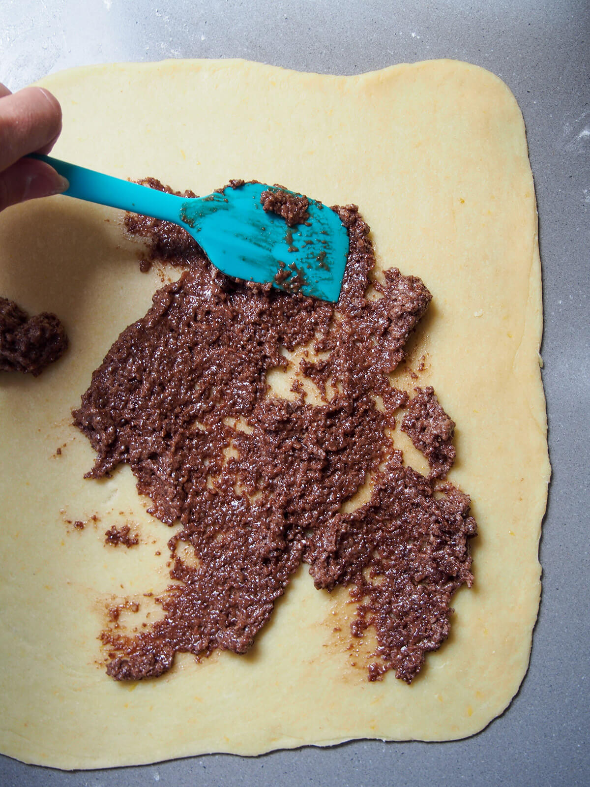 spreading filling over rolled out dough