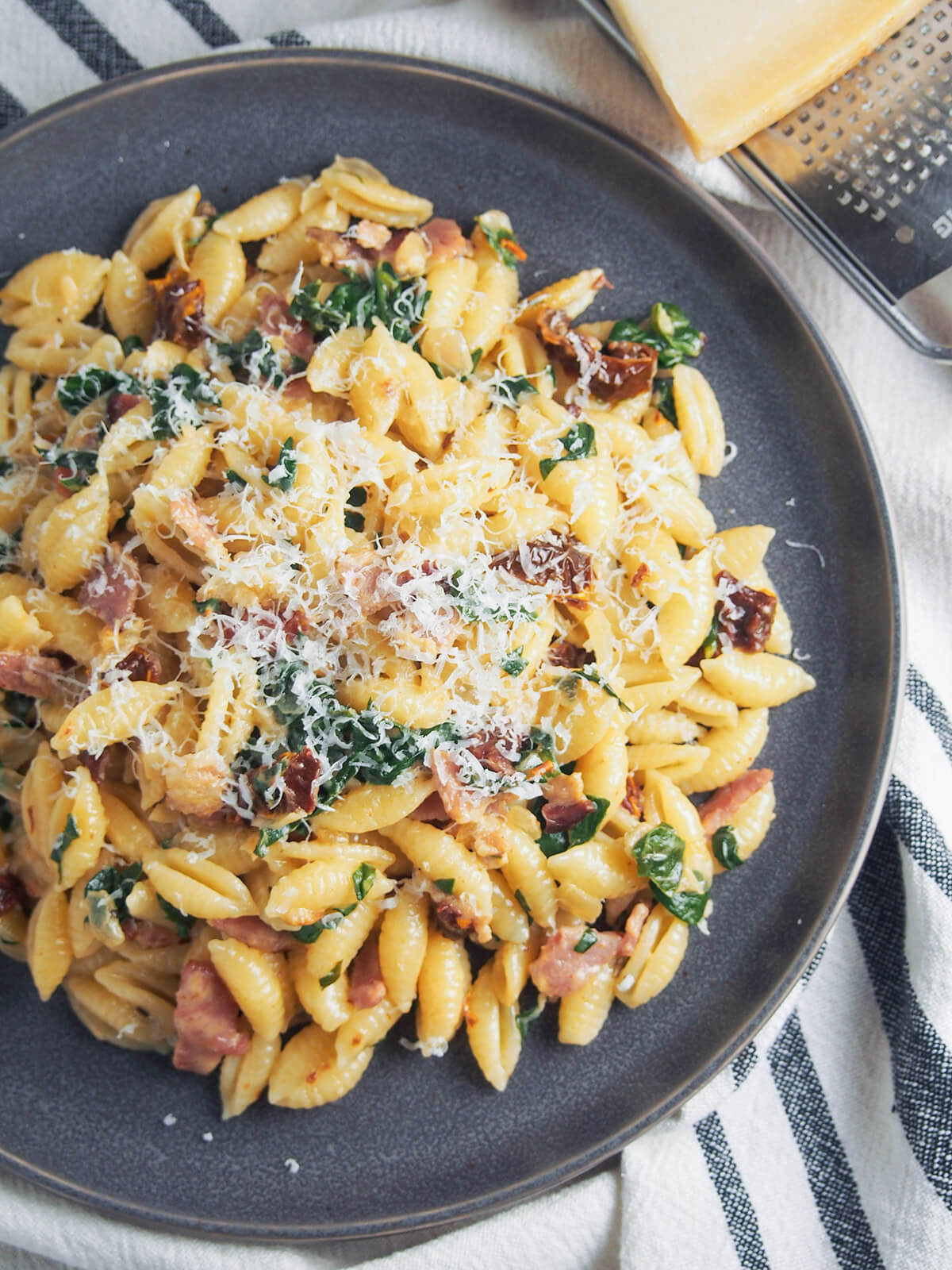 overhead view of plate of Bacon sun dried tomato pasta with spinach and cream