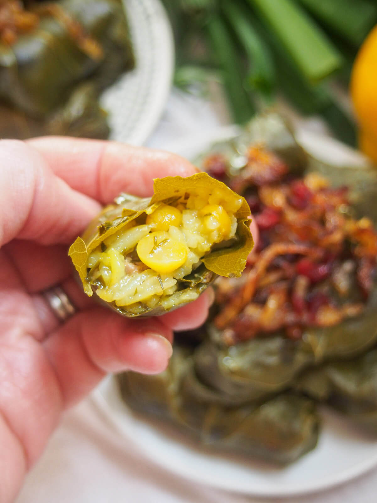 holding a bitten Persian stuffed grape leaf in hand showing filling inside