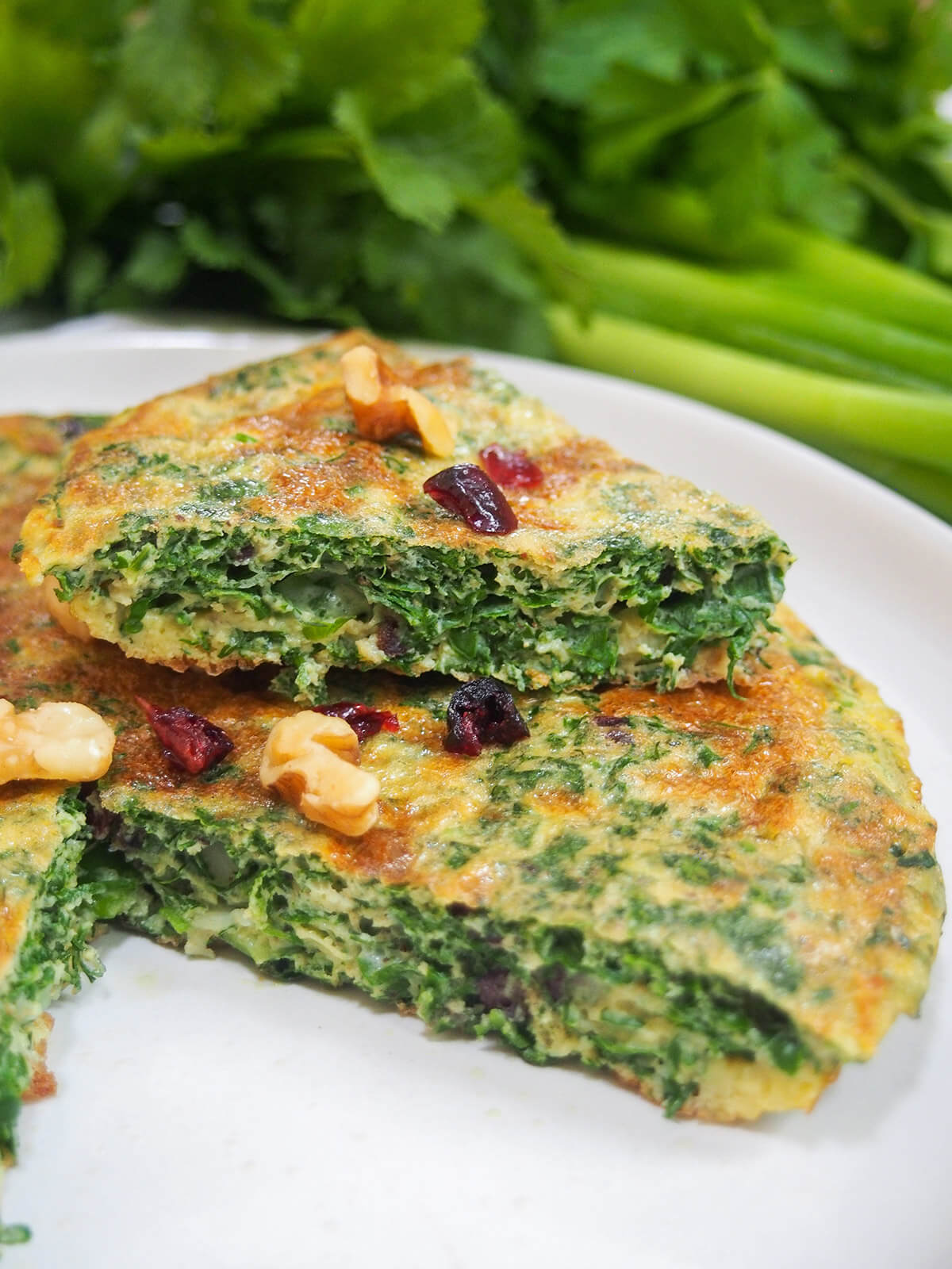 slice of kuku sabzi Persian herb frittata on top of rest