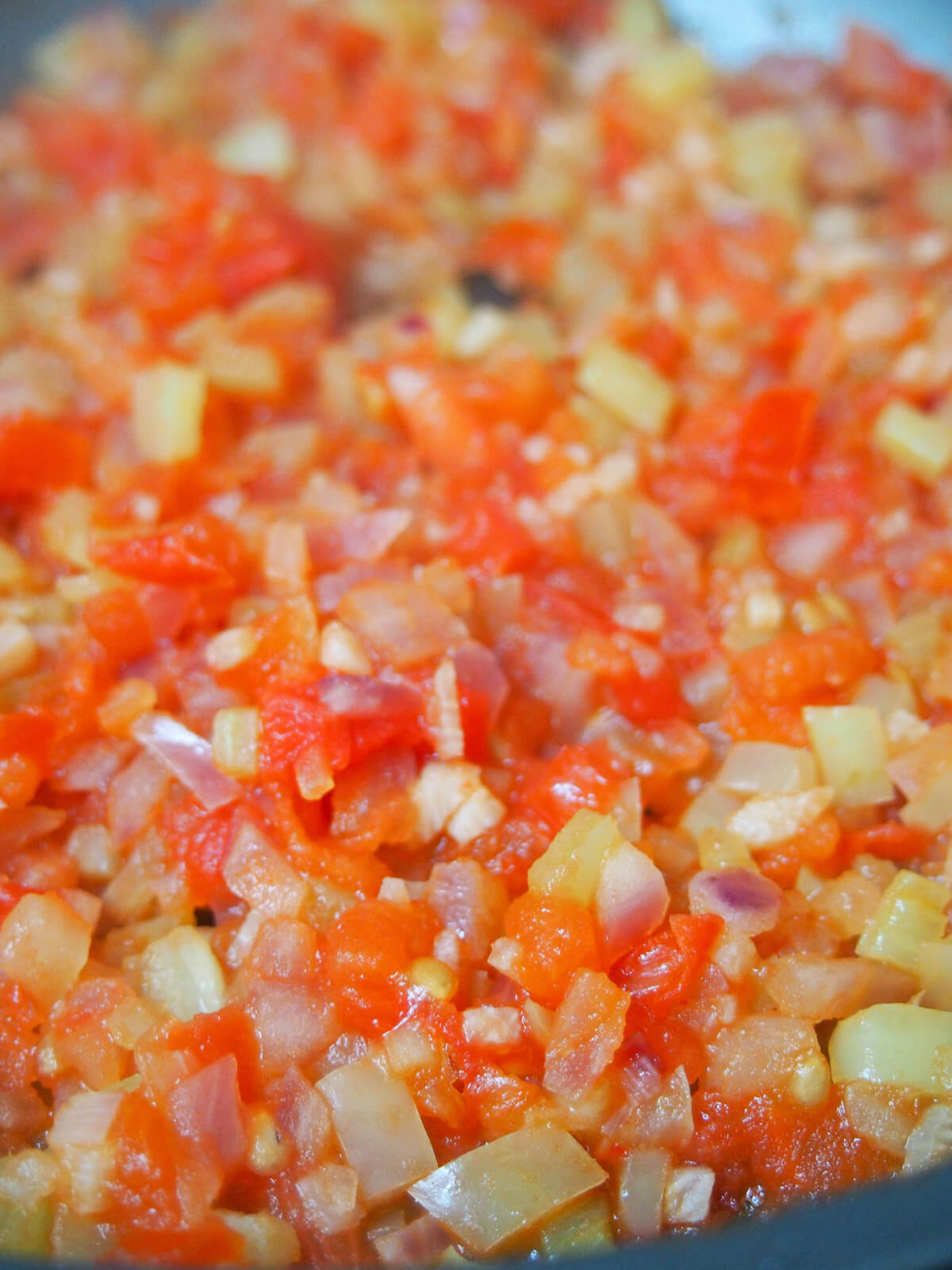 cooking tomato, onion and pepper in skilet