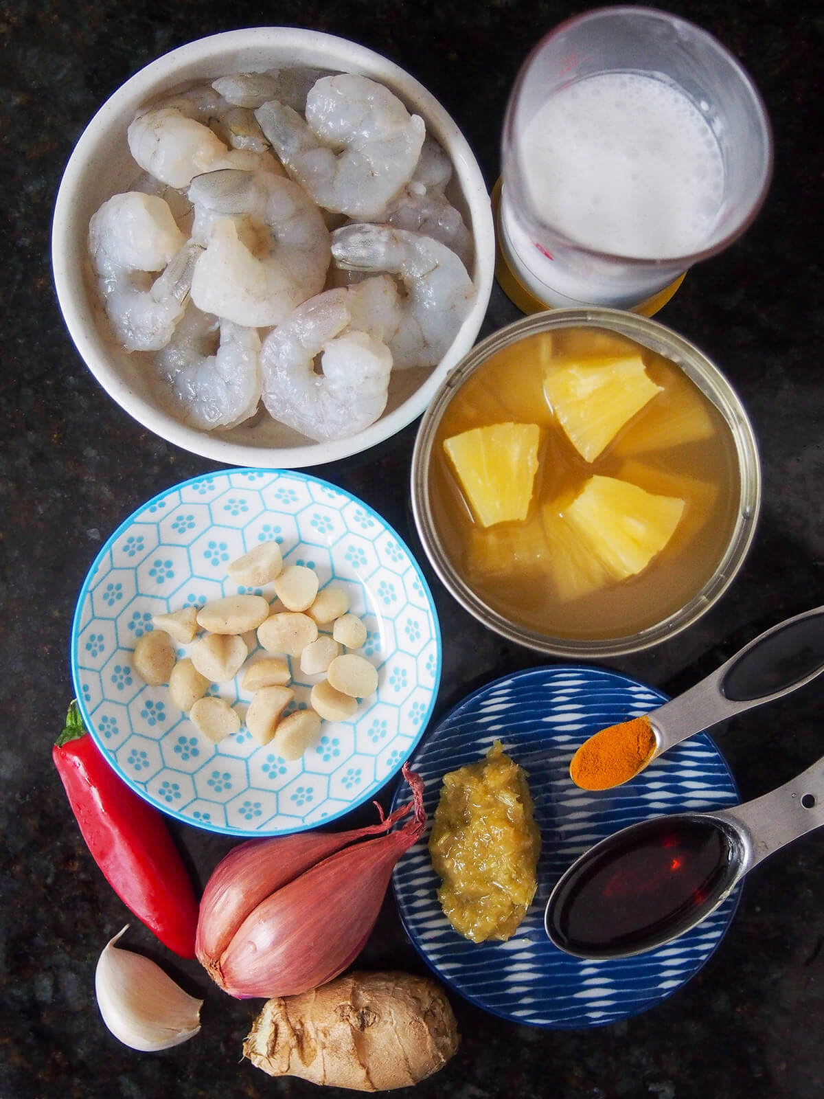bowls with shrimp, coconut milk, pineapple, nuts, chili, shallot, garlic ginger and other spices