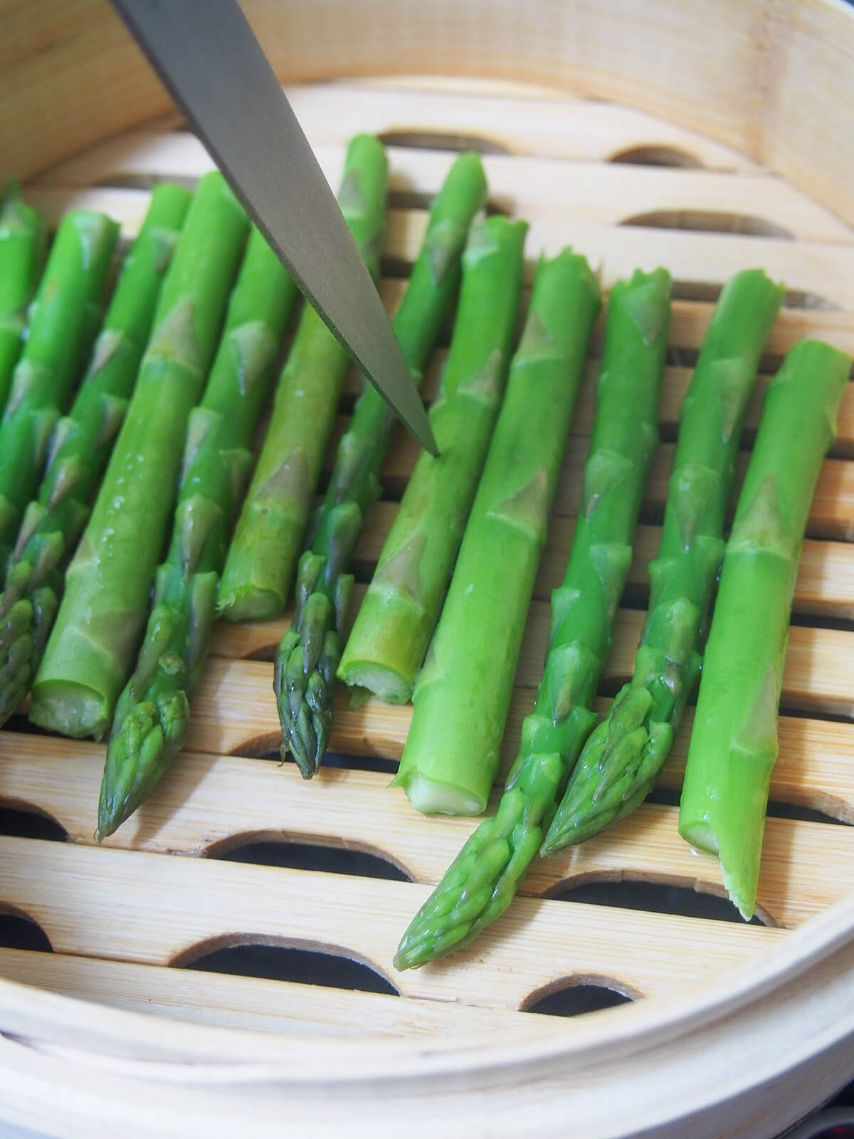 testing asparagus in steamer with knife
