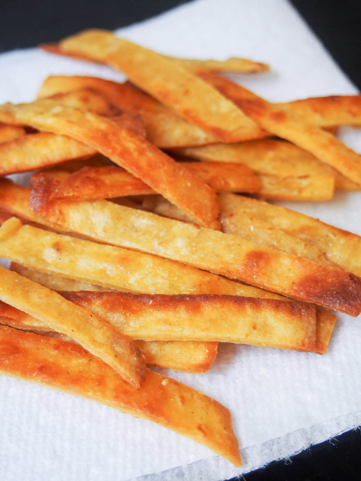 crisp tortilla strips draining on kitchen paper