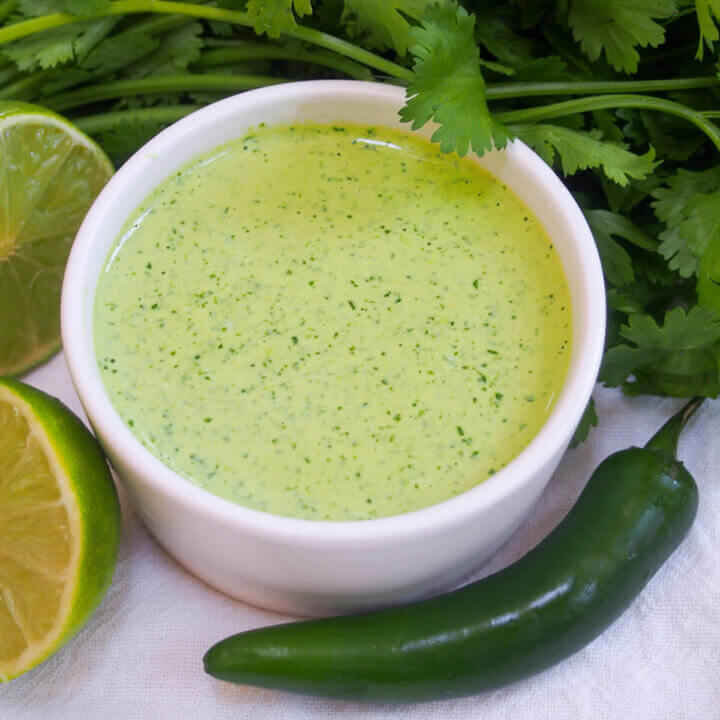 dish of aji verde Peruvian green sauce with chili in front