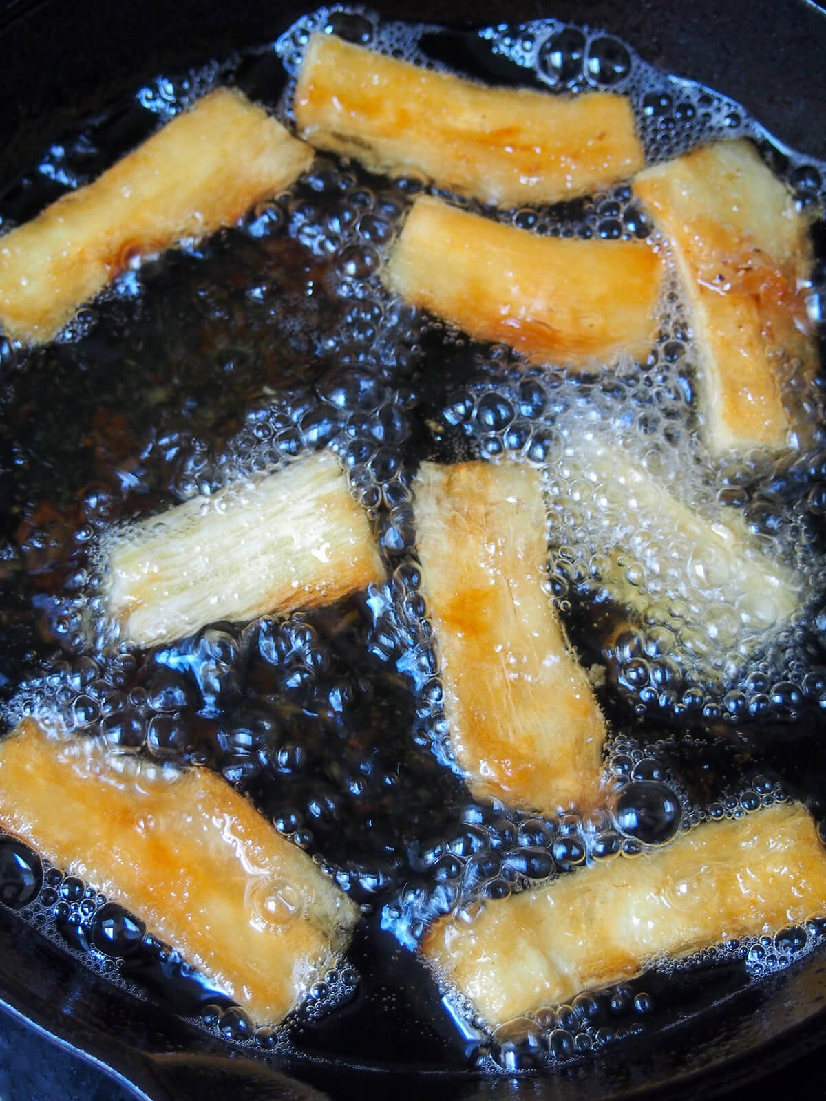 frying slices of yuca in oil
