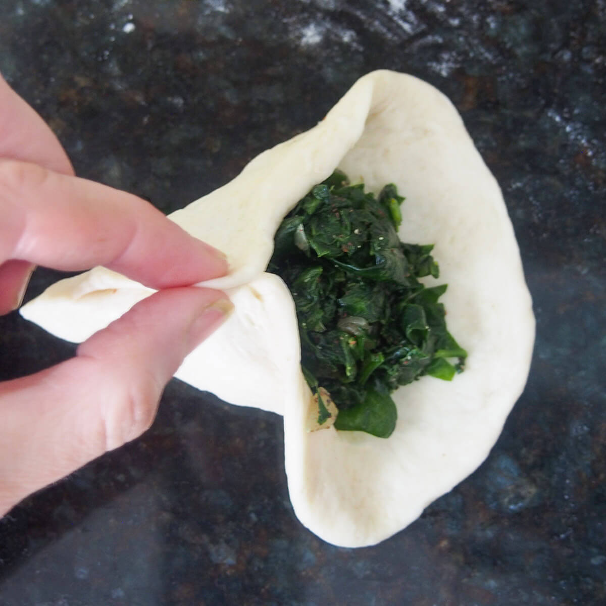 joining two side of pastry around spinach filling