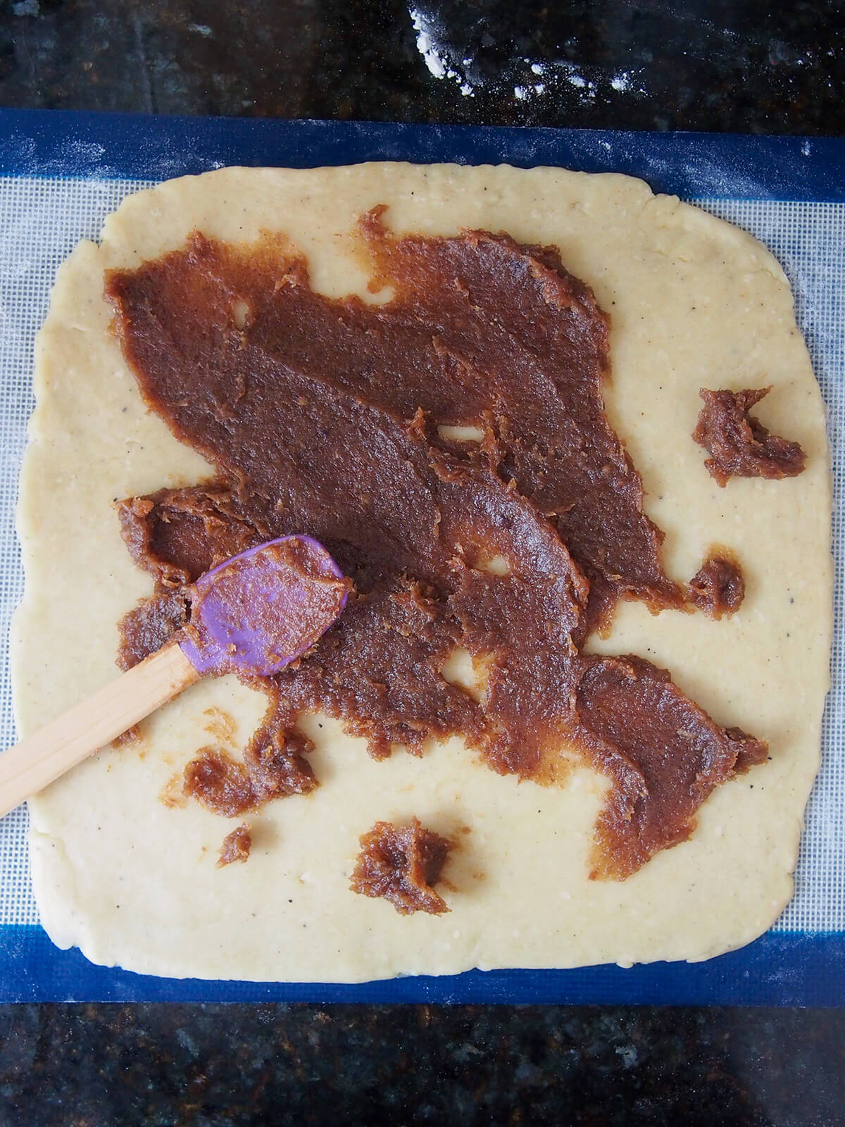 spreading date paste onto cookie dough