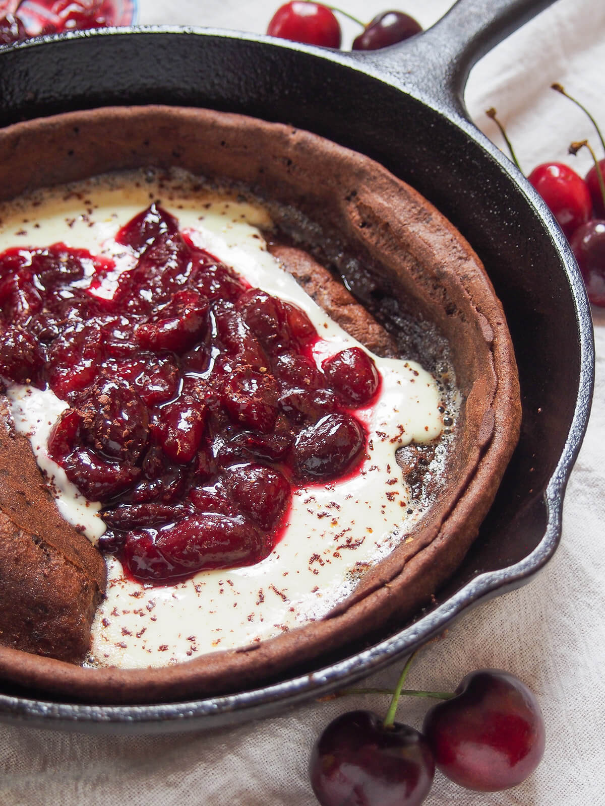 side part view of chocolate Dutch baby pancake with cherry compote