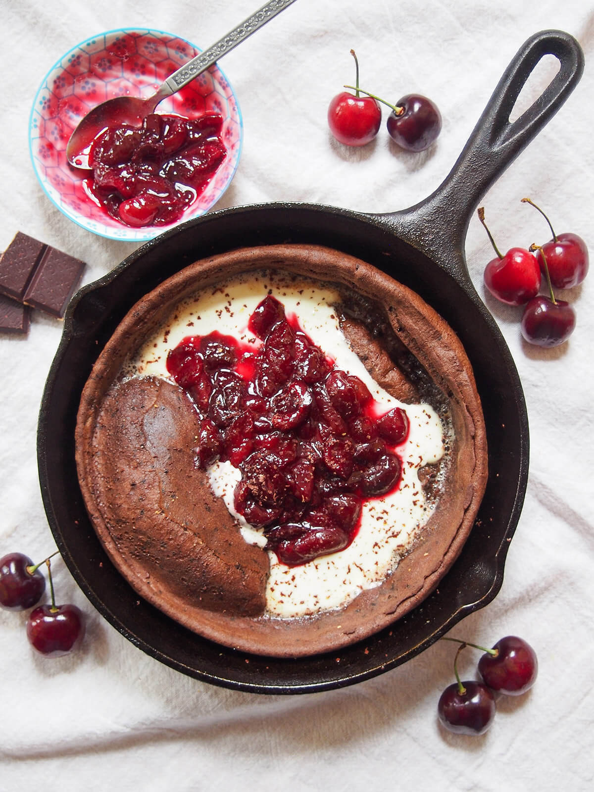 overhead view of chocolate Dutch baby pancake with cherry compote