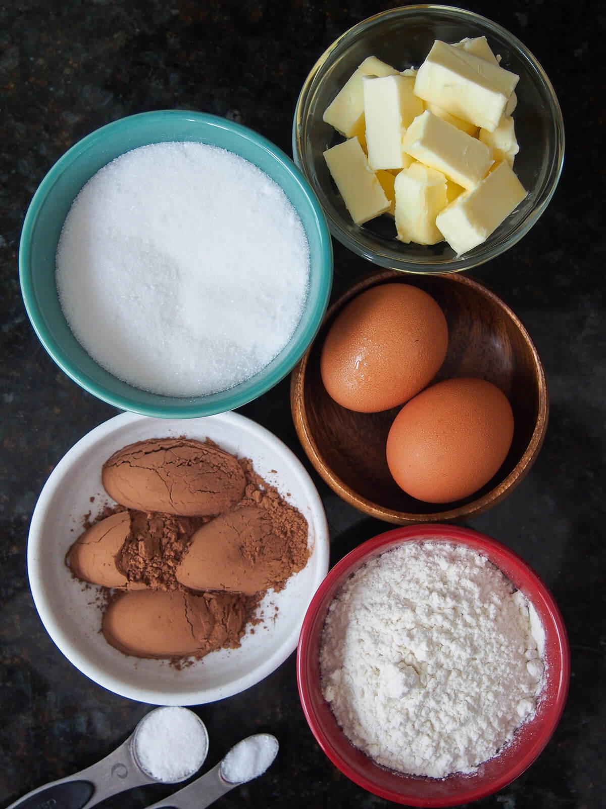 bowls with butter, sugar, eggs, flour and cocoa powder