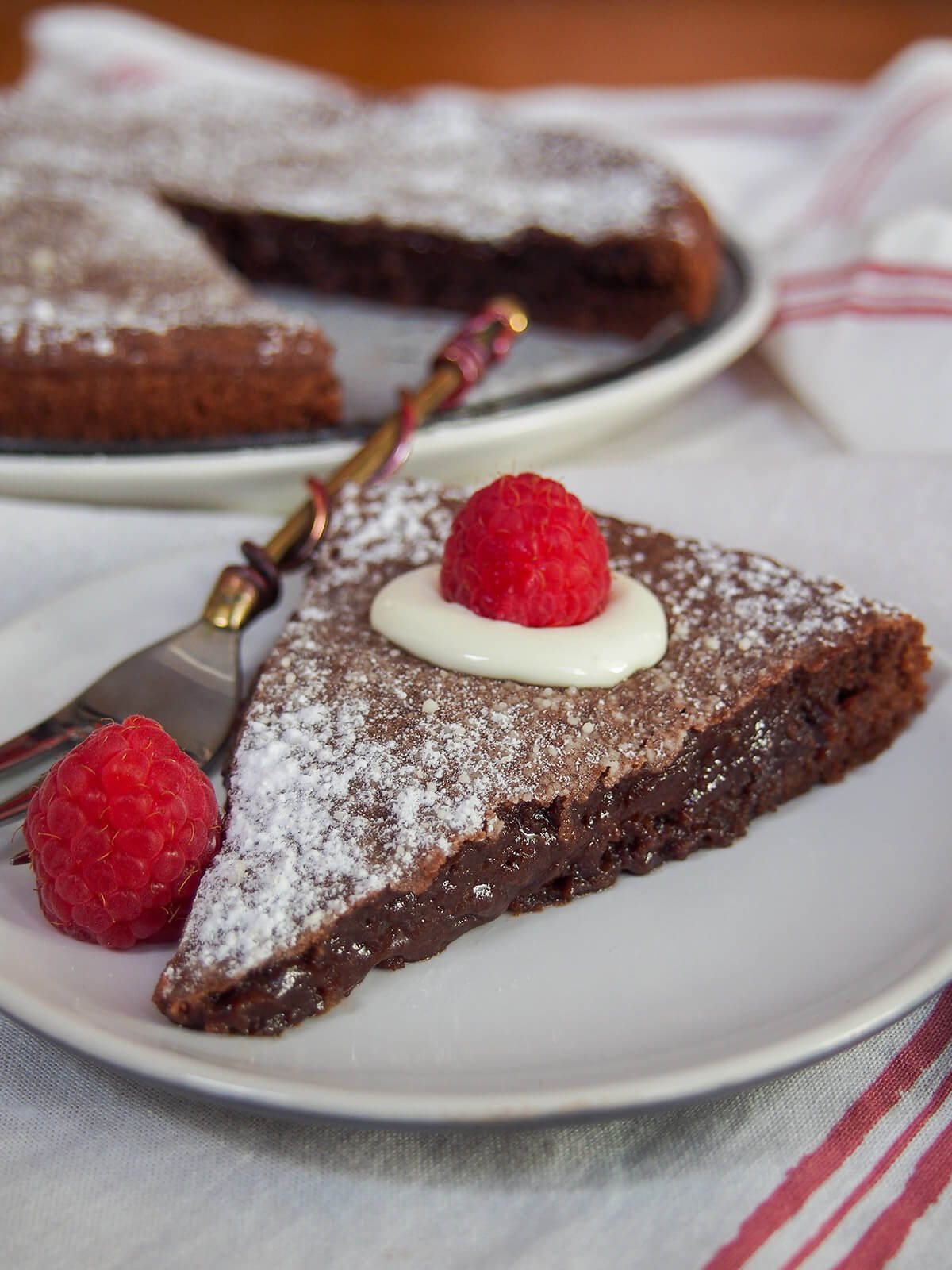 a slice of kladdkaka Swedish sticky chocolate cake with rest behind