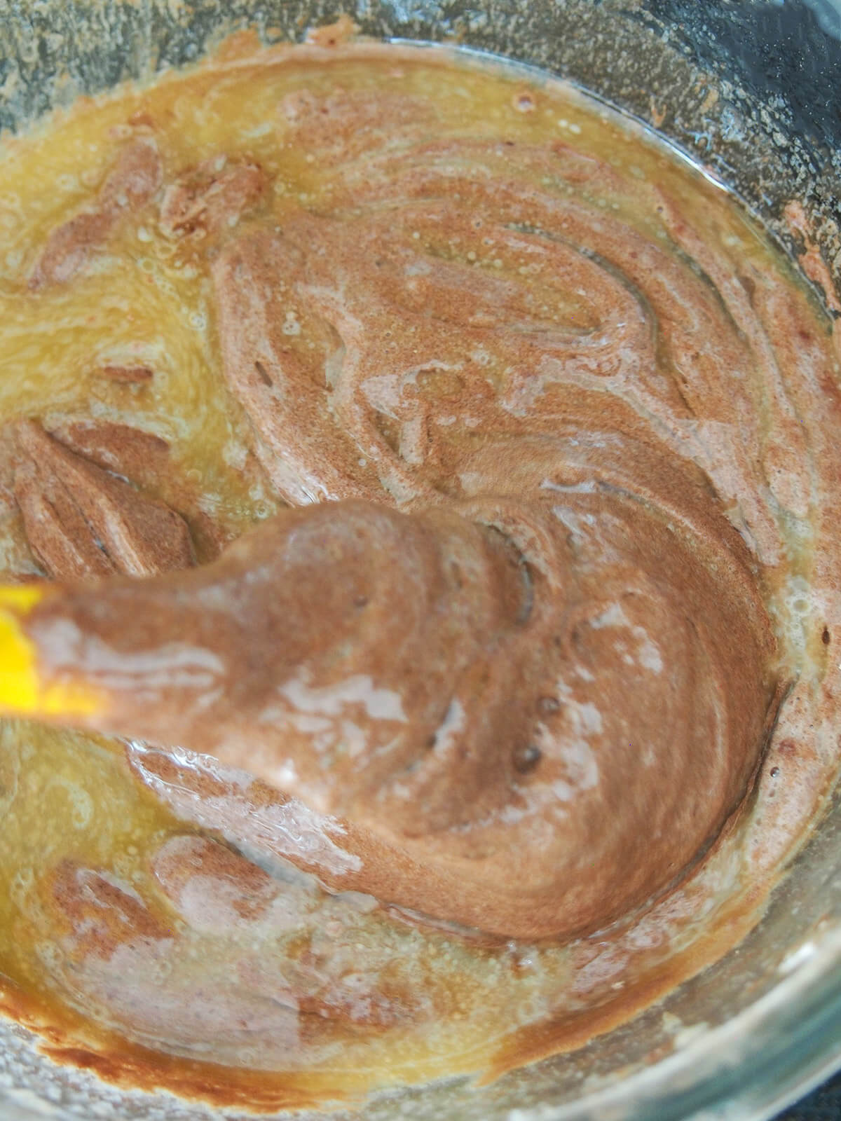 mixing melted butter into chocolate cake batter