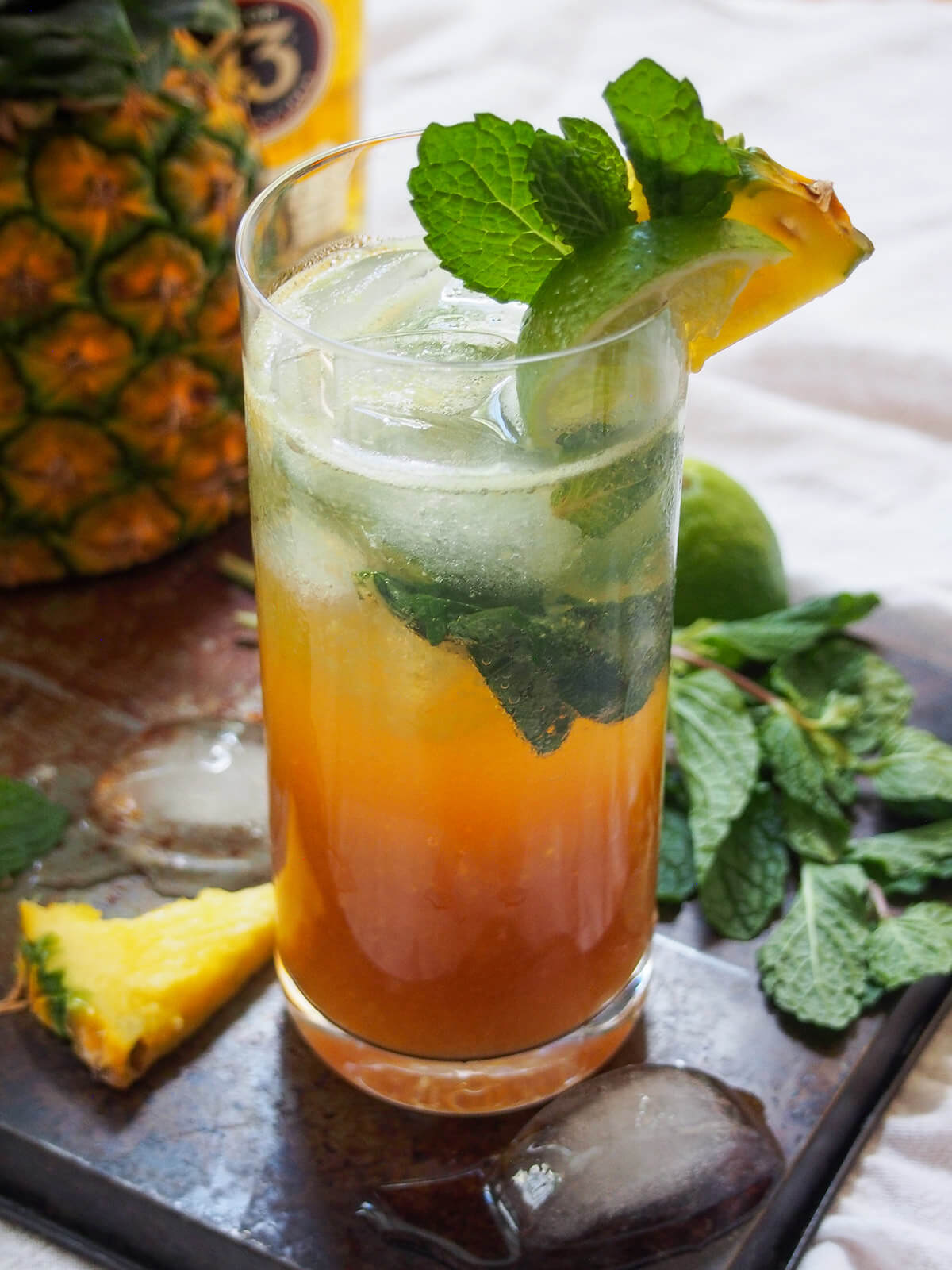 glass of 43 pineapple mojito with pineapple behind glass