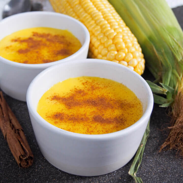 dish of Brazilian corn pudding with another and corn cob behind