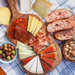 Spanish cheese board with tomato bread, pieces of cheese around board