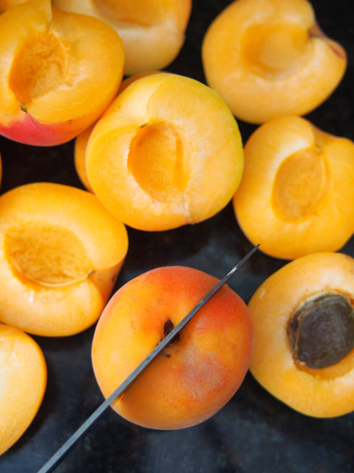 cutting apricots for apricot cake marillenkuchen cutting apricots in half and removing stones