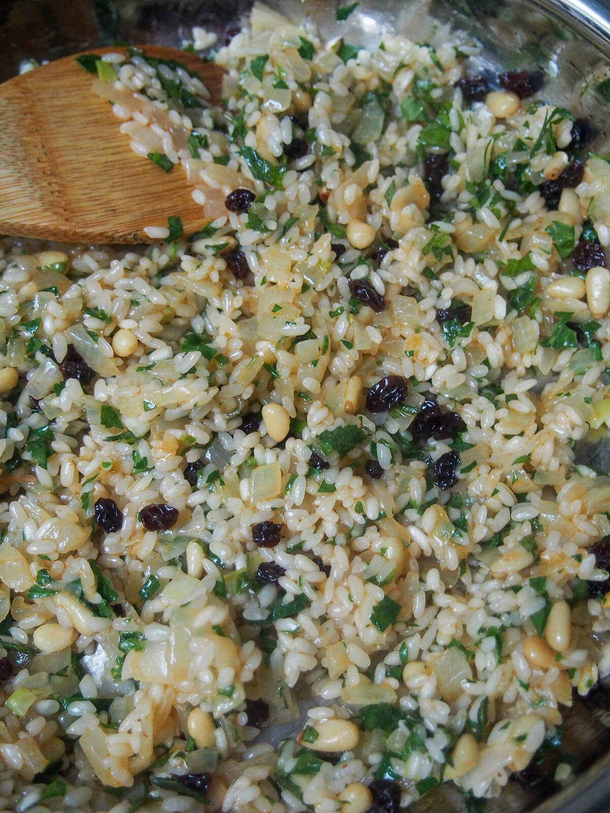 skillet with rice, currants, pine nuts and herb mixture