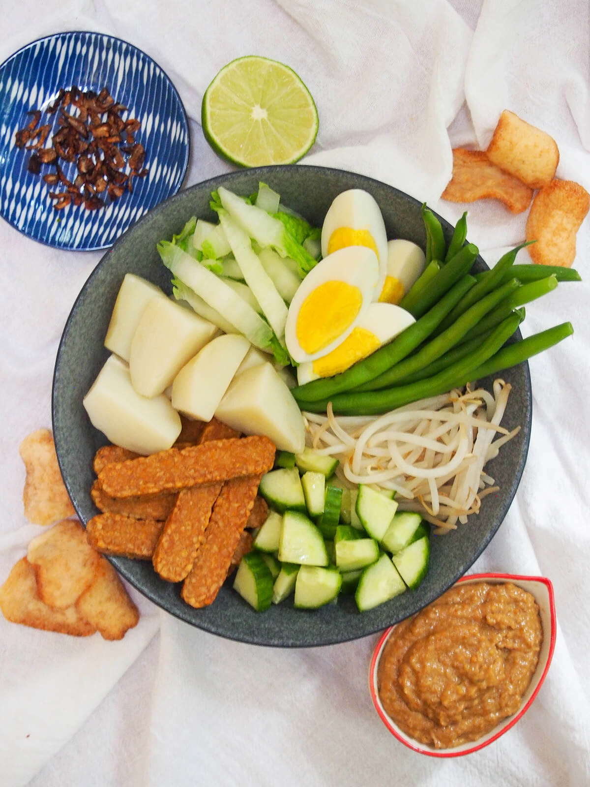 overhead view of gado gado salad before adding peanut dressing in bowl to side