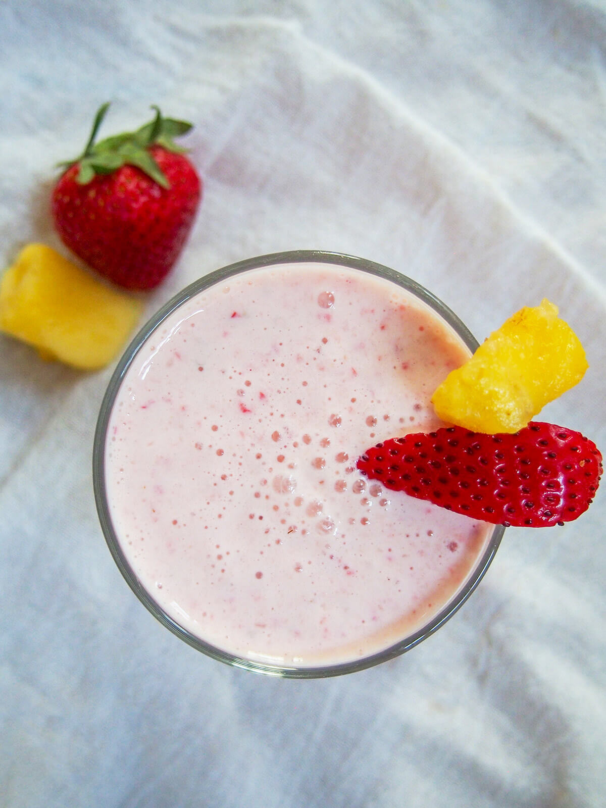 overhead view of glass of strawberry pineapple smoothie