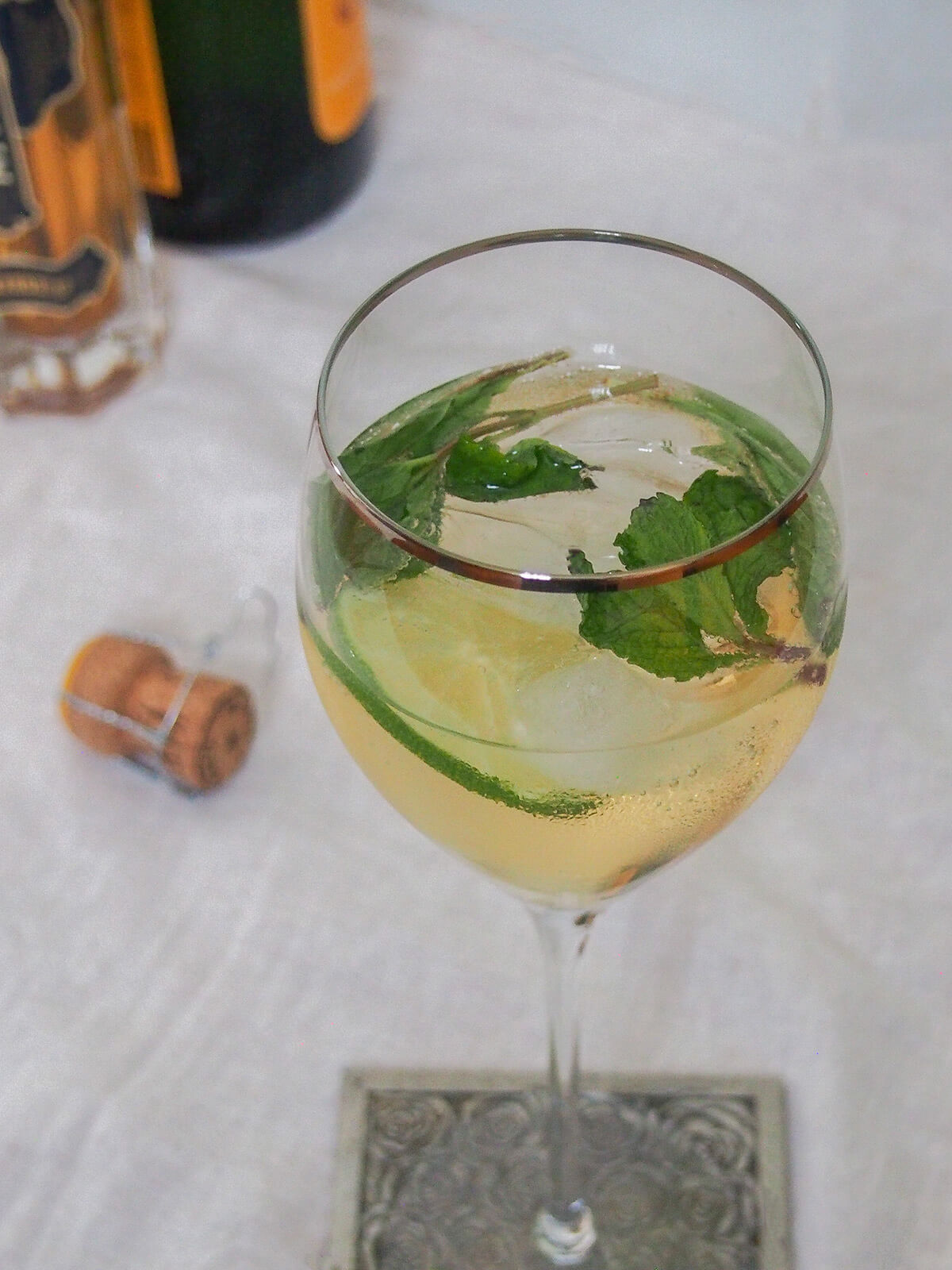 This Hugo spritz cocktail is easy to make, with a bright, refreshing flavor. It has a touch of aromatic sweetness from the St Germain, gentle bubbles and is nicely light. Perfect summer sipping. glass of Hugo spritz cocktail with cork to side