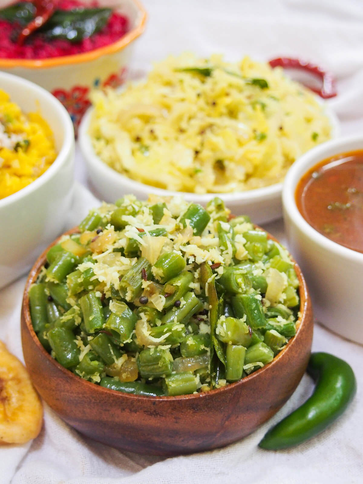 bowl of beans thoran with cabbage thoran and other dishes in background
