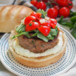 lamb burger with feta sauce topped with tomatoes