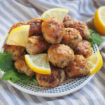 plate of lemon pork meatballs or polpette with wedges of lemon