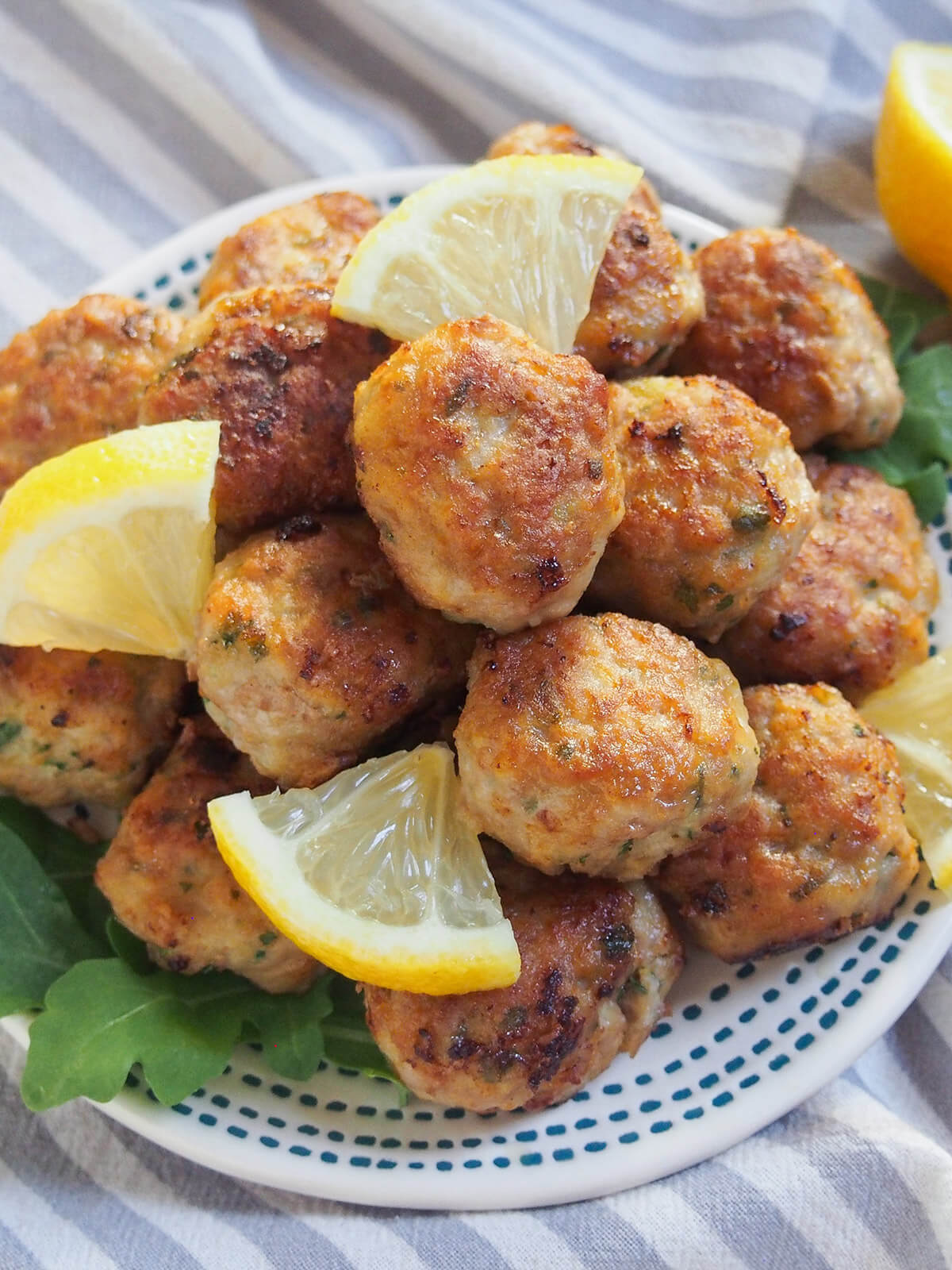 overhead view of stack of lemon pork meatballs with lemon wedges to side