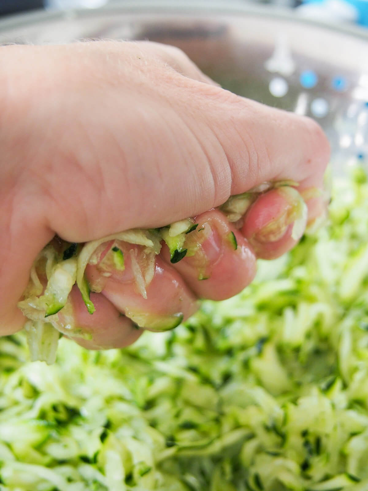 squeezing liquid from grated zucchini