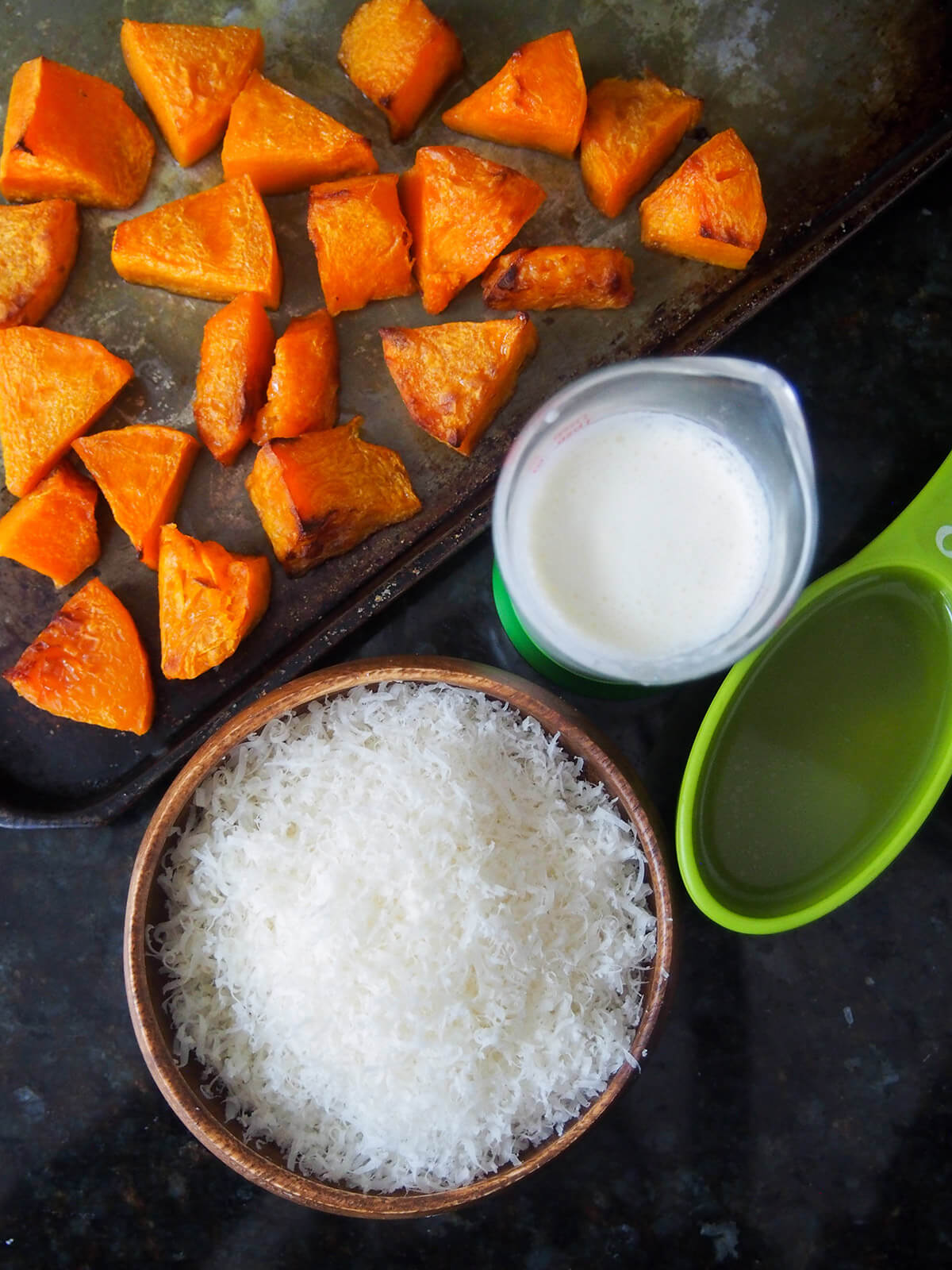 baking sheet with roast butternut squash next to bowl of parmesan, cream and stock