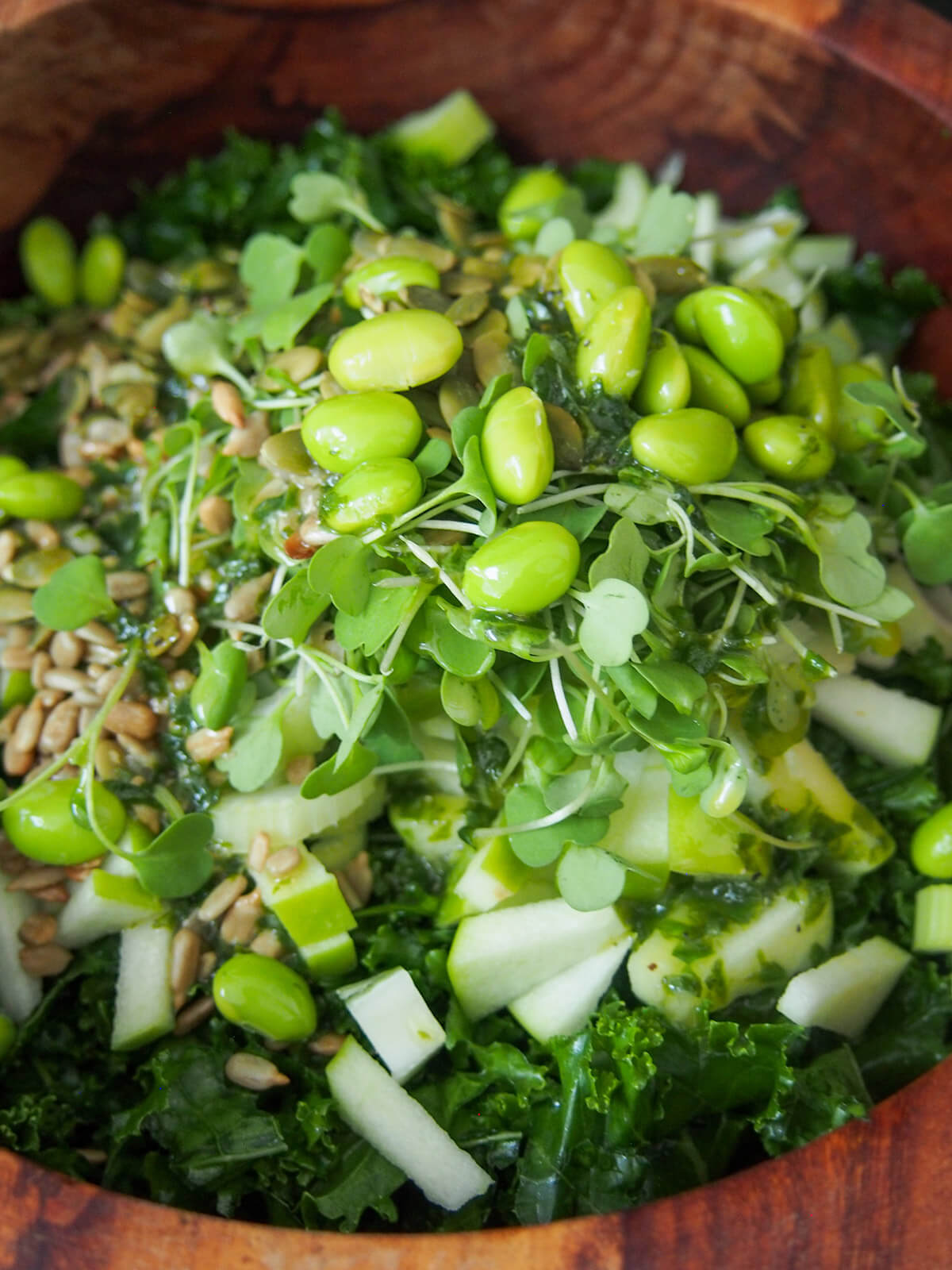 edamame on top of microgreens, apple, seeds and kale below
