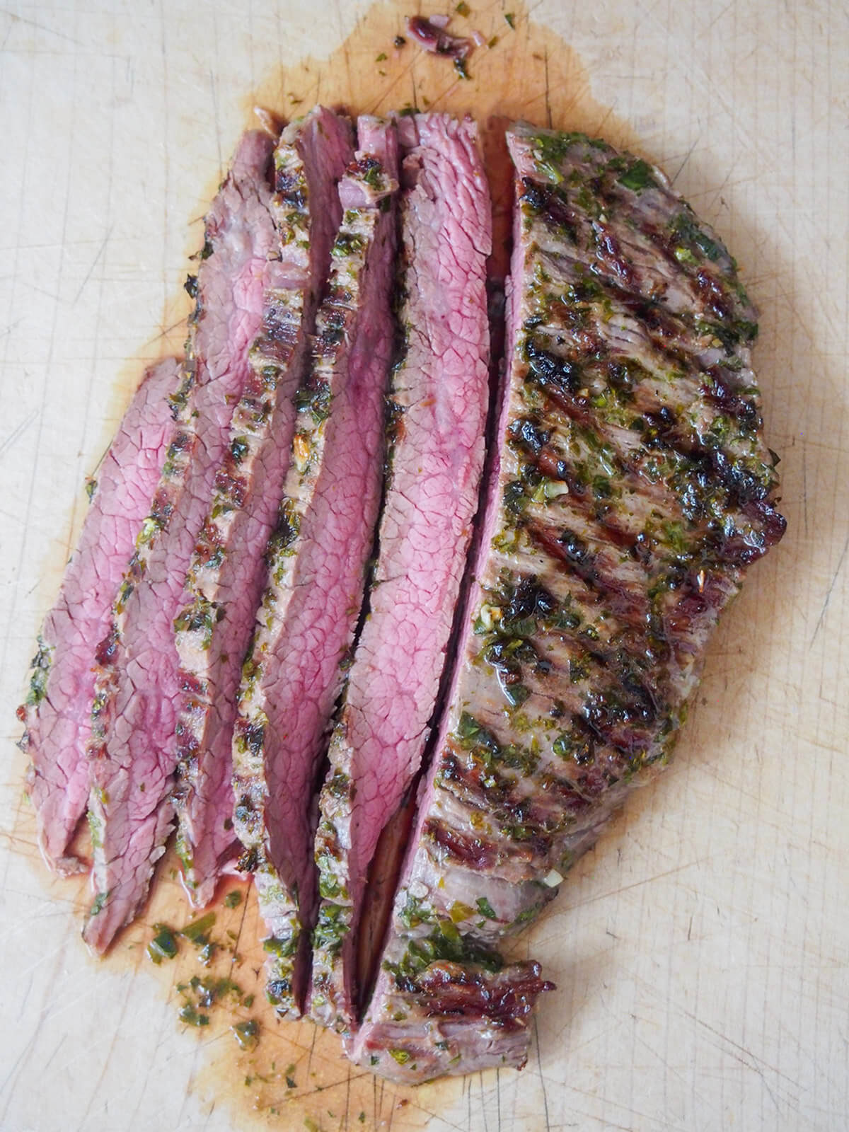slicing chimichurri marinated steak slicing steak on cutting board